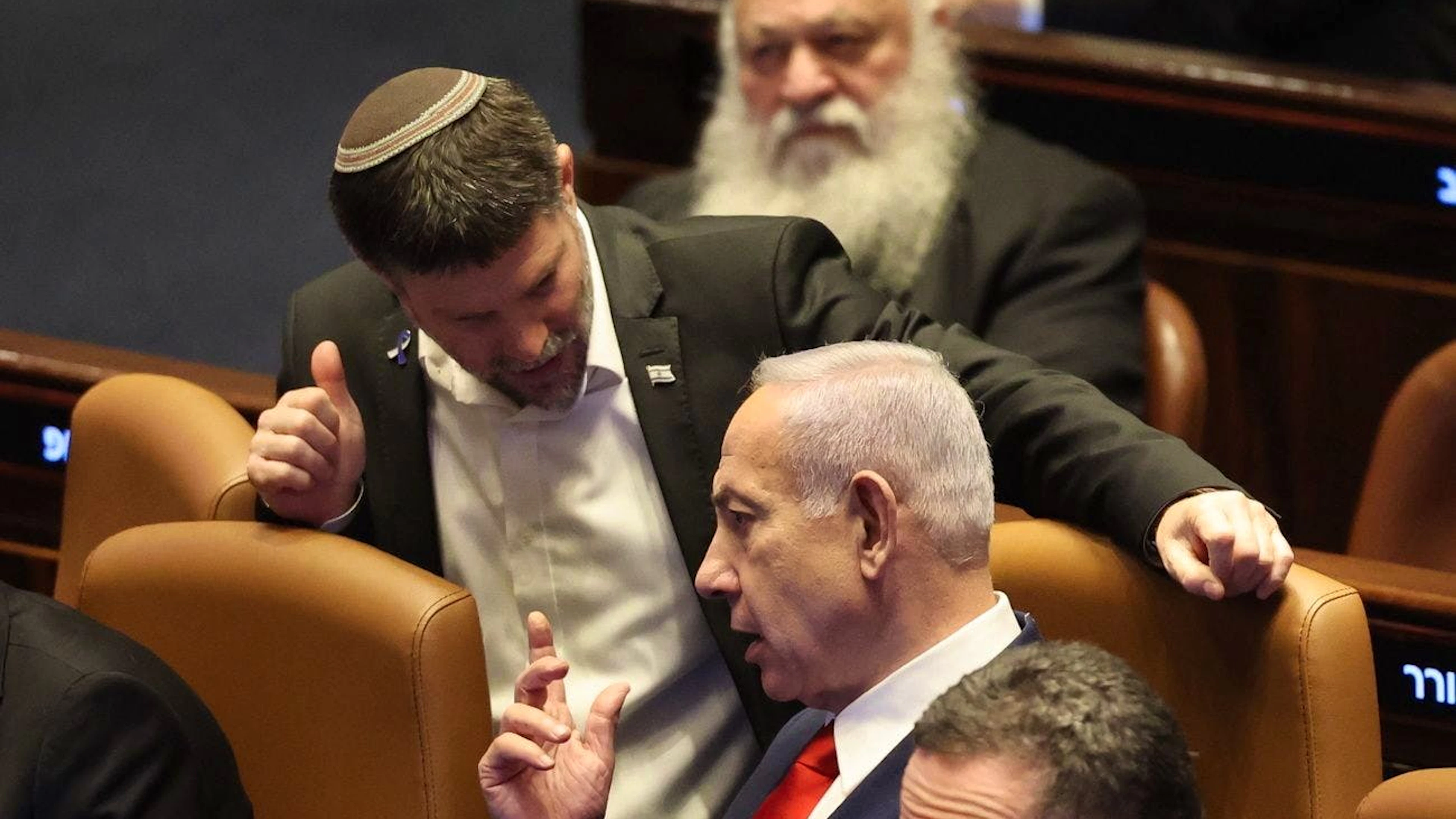 Il primo ministro israeliano Benjamin Netanyahu (centro) parla con il suo ministro delle finanze Bezalel Smotrich