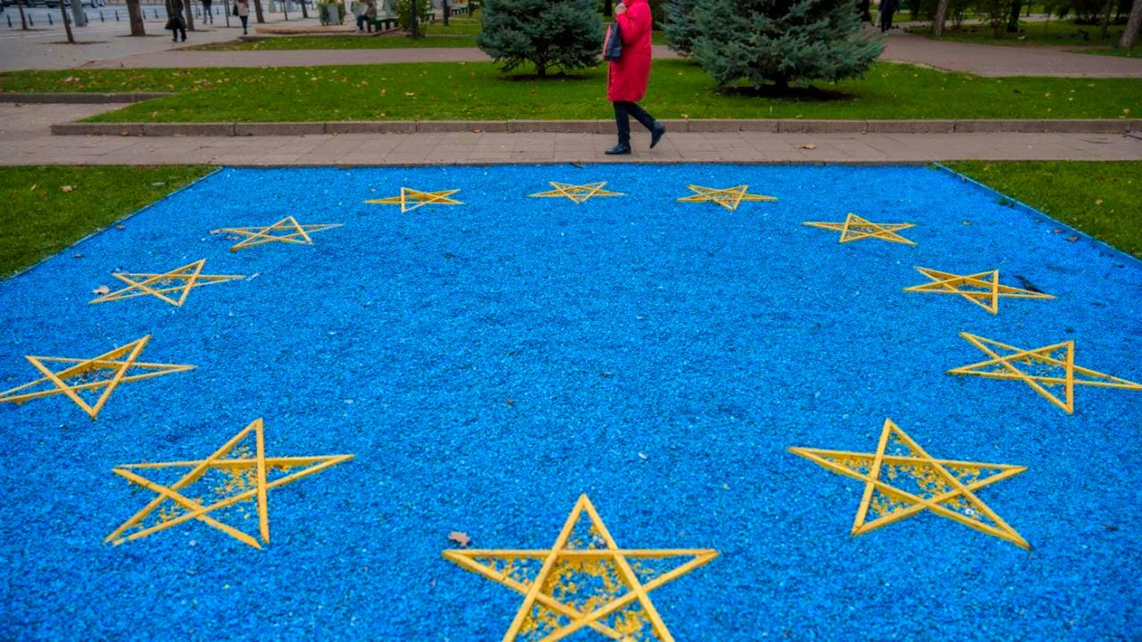 ARCHIV - Eine Frau geht an einer EU-Flagge aus blauen Kieselsteinen vorbei. Foto: Vadim Ghirda/AP/dpa