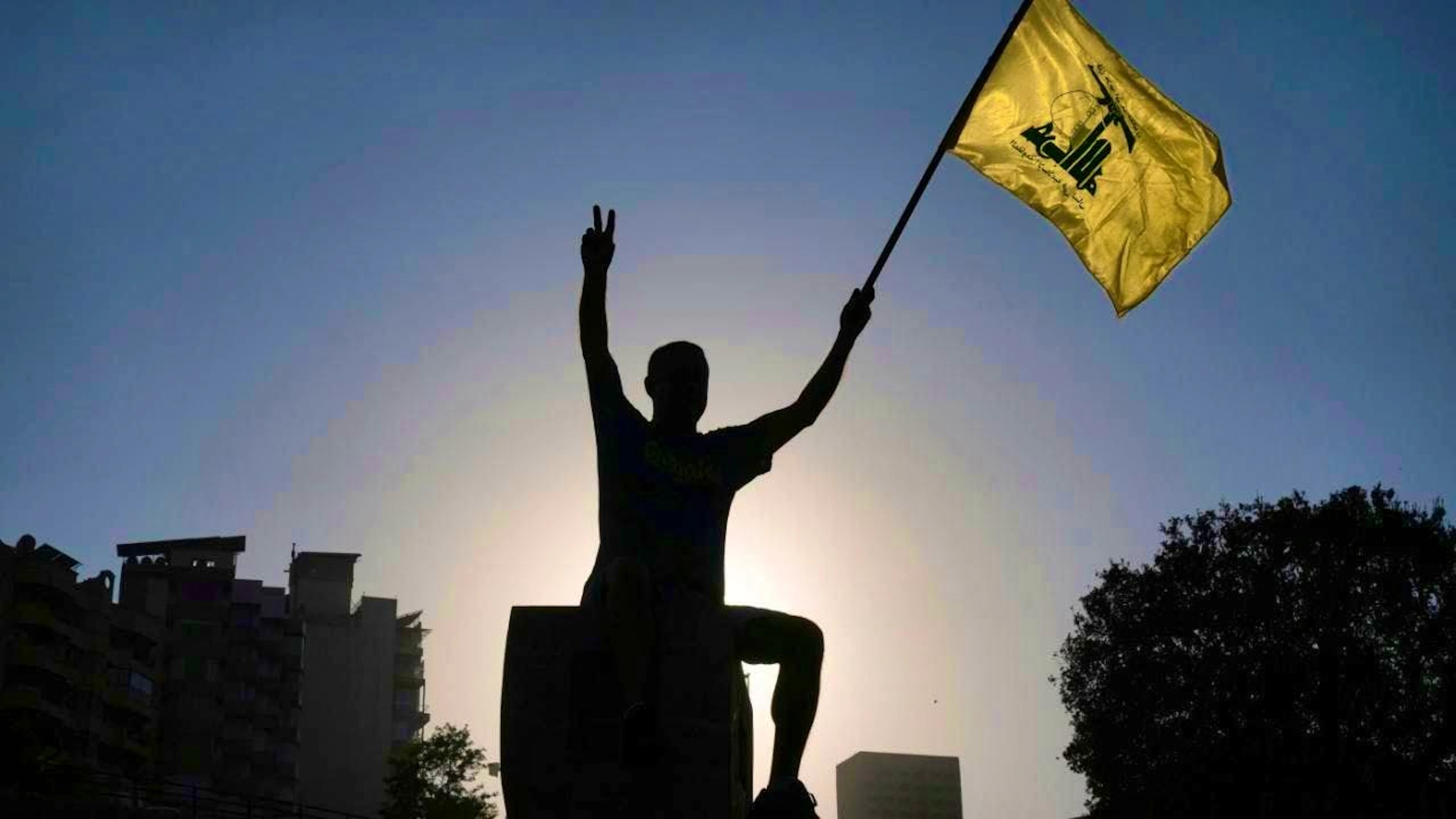 dpatopbilder - A Hezbollah supporter holds up a Hezbollah flag in front of the headquarters of the UN Economic and Social Commission for Western Asia (ESCWA) during a demonstration against the Israeli war and the alleged starvation of the civilian population in the Gaza Strip. Photo: Bilal Hussein/AP/dpa