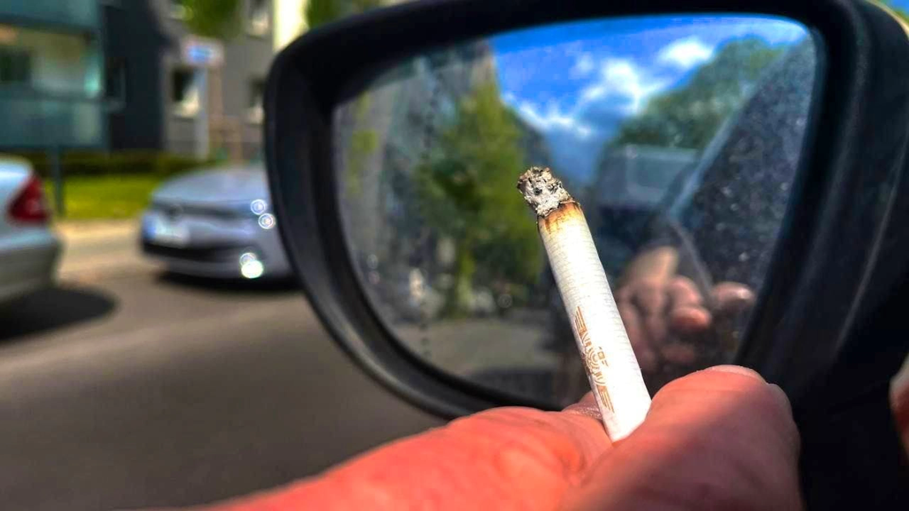 ARCHIVE - A person smokes a cigarette while driving. Photo: Paul Zinken/dpa/archive