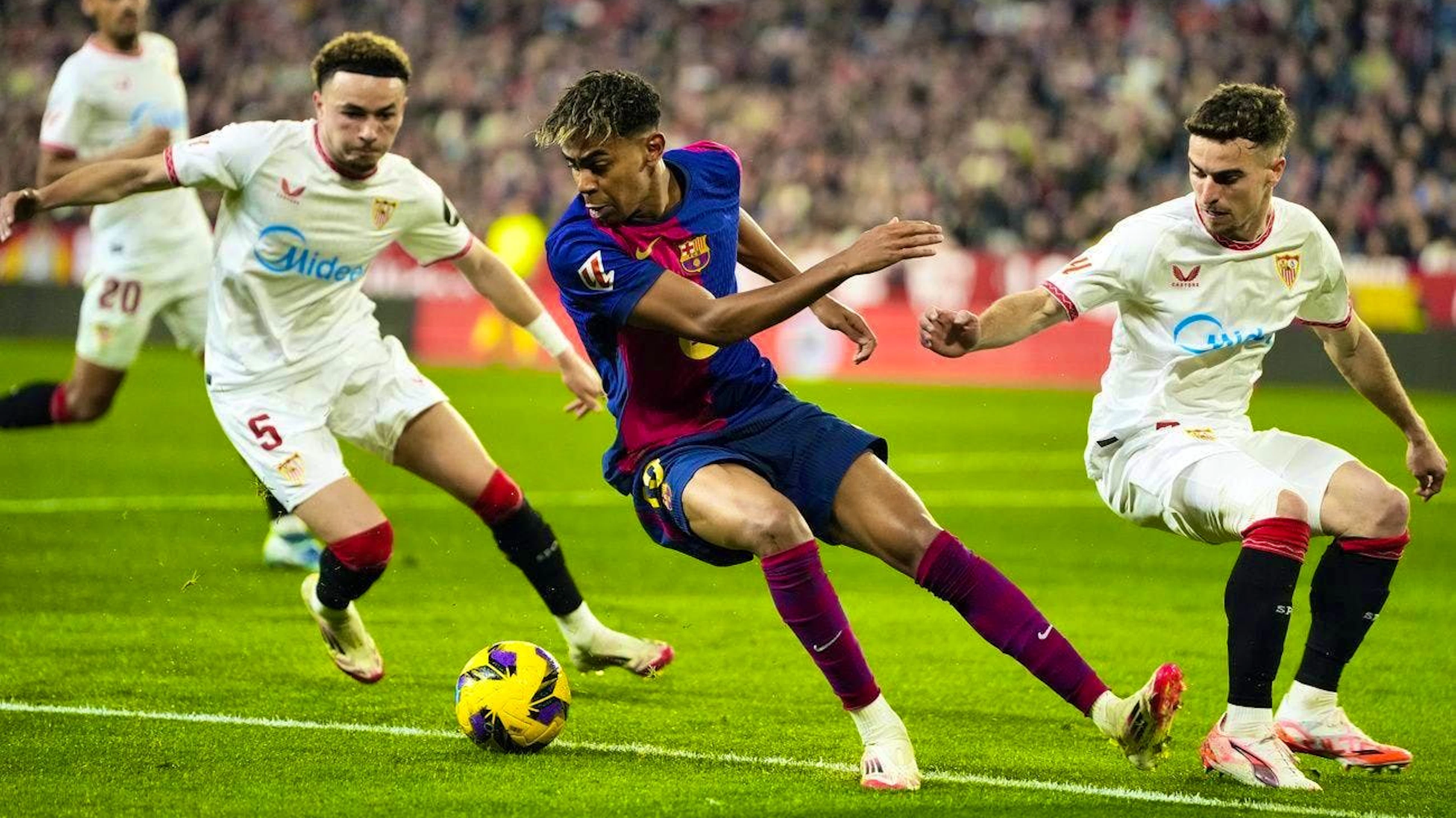 Ruben Vargas (l.) tries to steal the ball from Barça's Lamine Yamal with team-mate Adria Pedrosa.