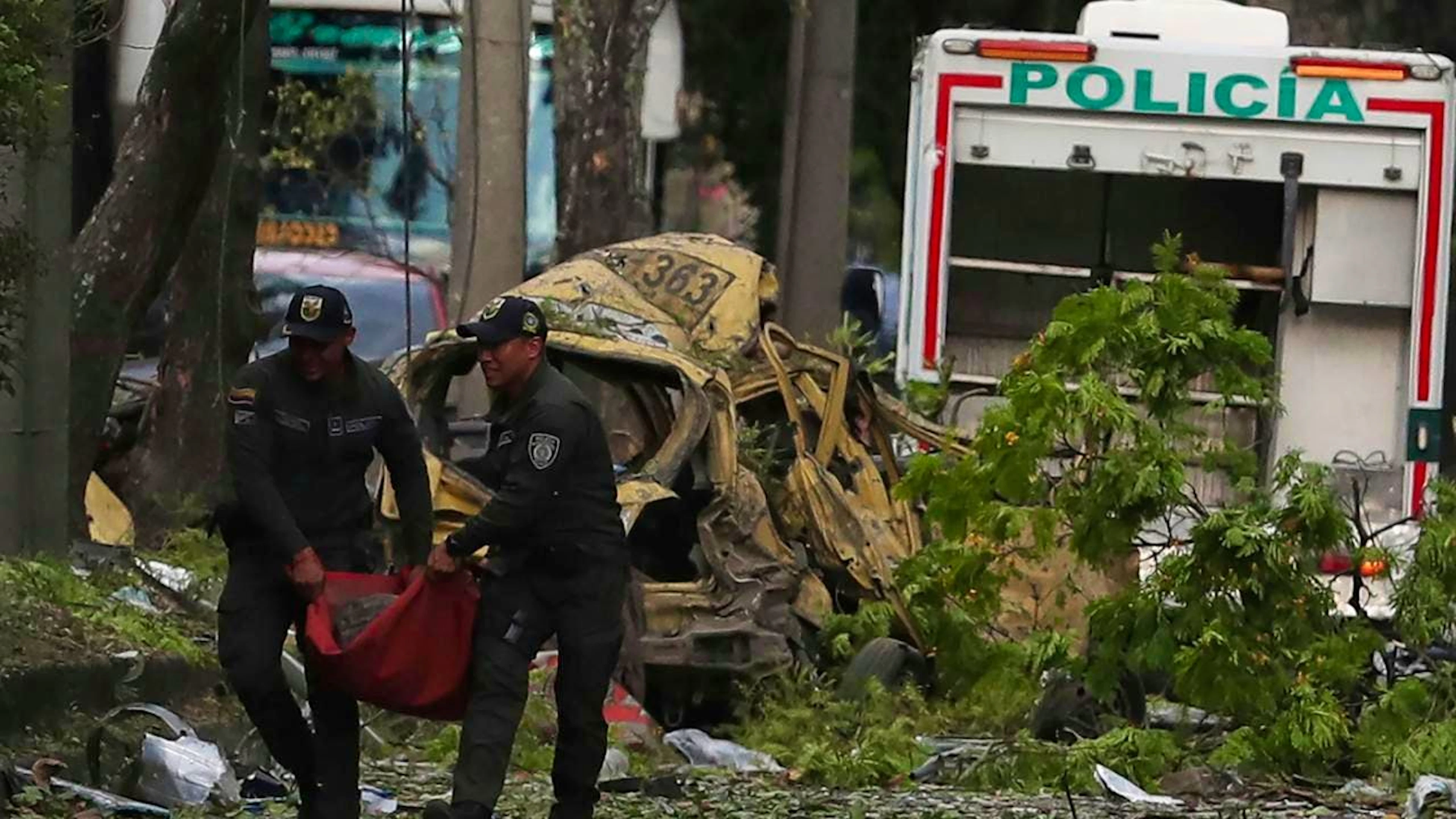 dpatopbilder - Die Polizei beseitigt die Trümmer einer Bombenexplosion vor einem Luftwaffenstützpunkt. Foto: Santiago Saldarriaga/AP/dpa