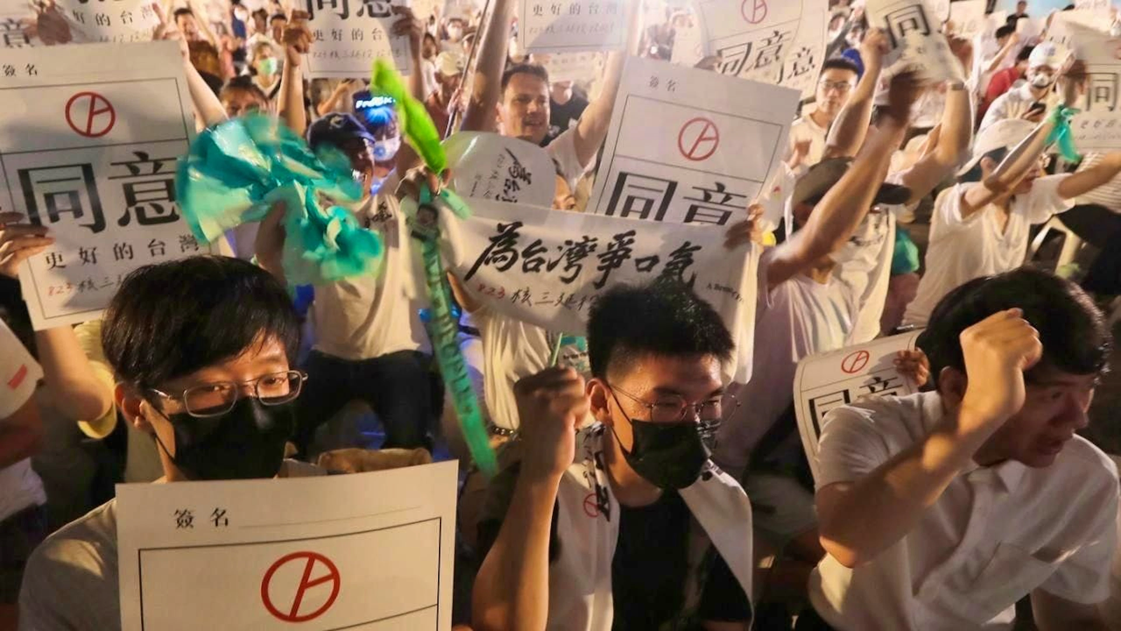 People hold signs reading "Approval" in support of a referendum held in favor of extending the operation of the third nuclear power plant in Taipei. Photo: ChiangYing-ying/AP/dpa