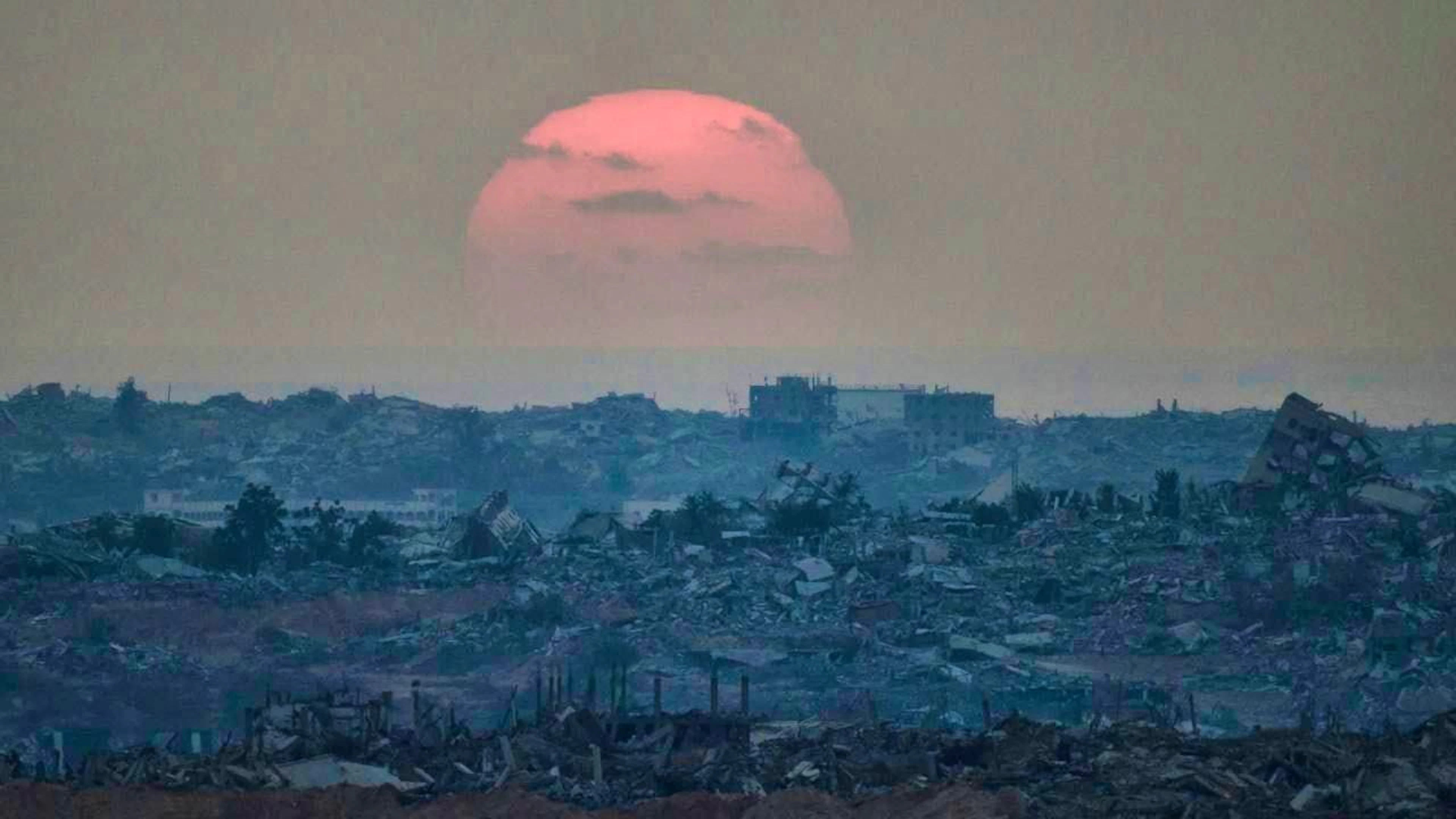 ARCHIVE - The sun sets behind destroyed buildings in the Gaza Strip (archive photo). Photo: Leo Correa/AP/dpa