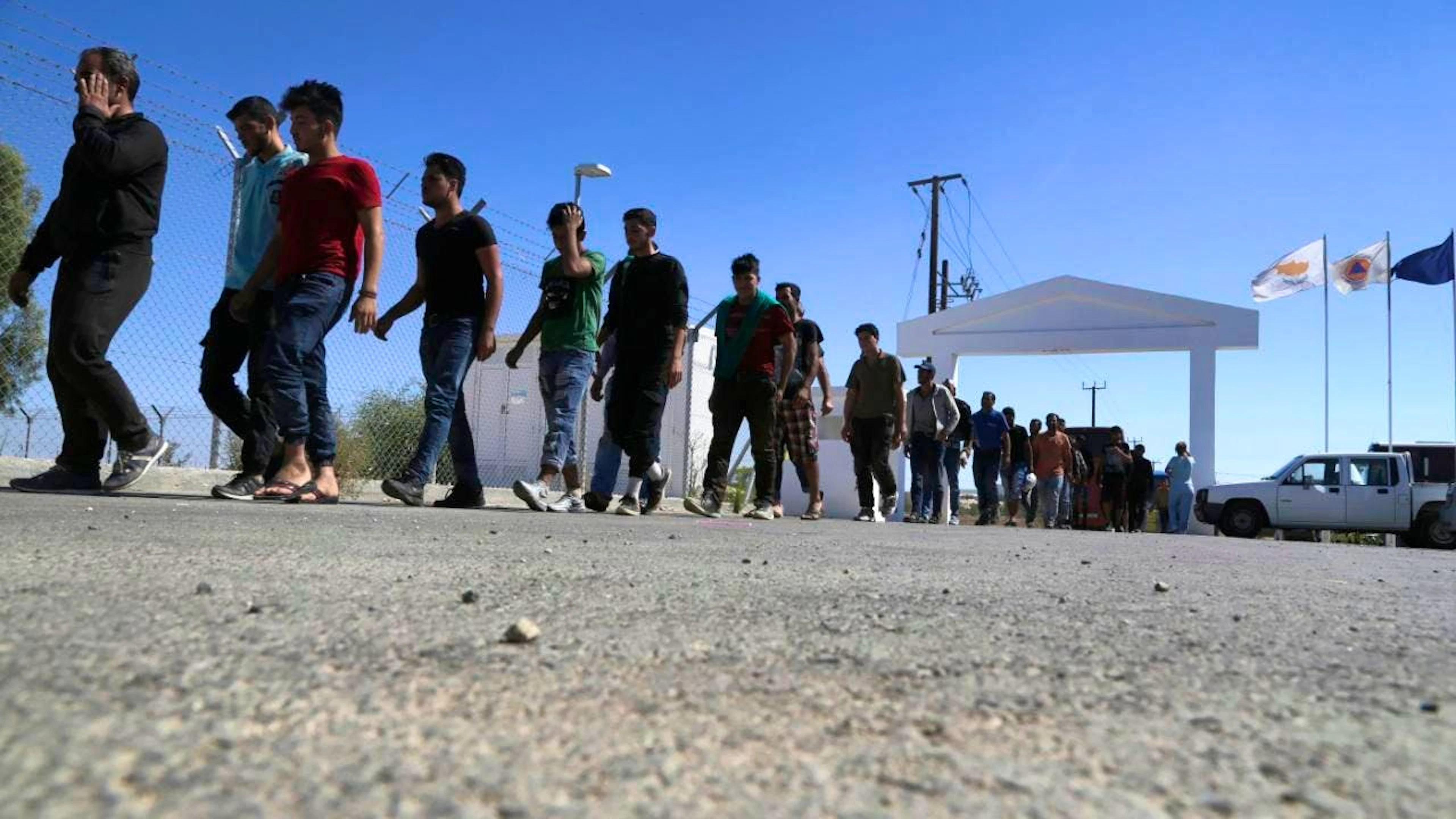 MIgranti siriani all'ingresso di un campo profughi a Cipro.