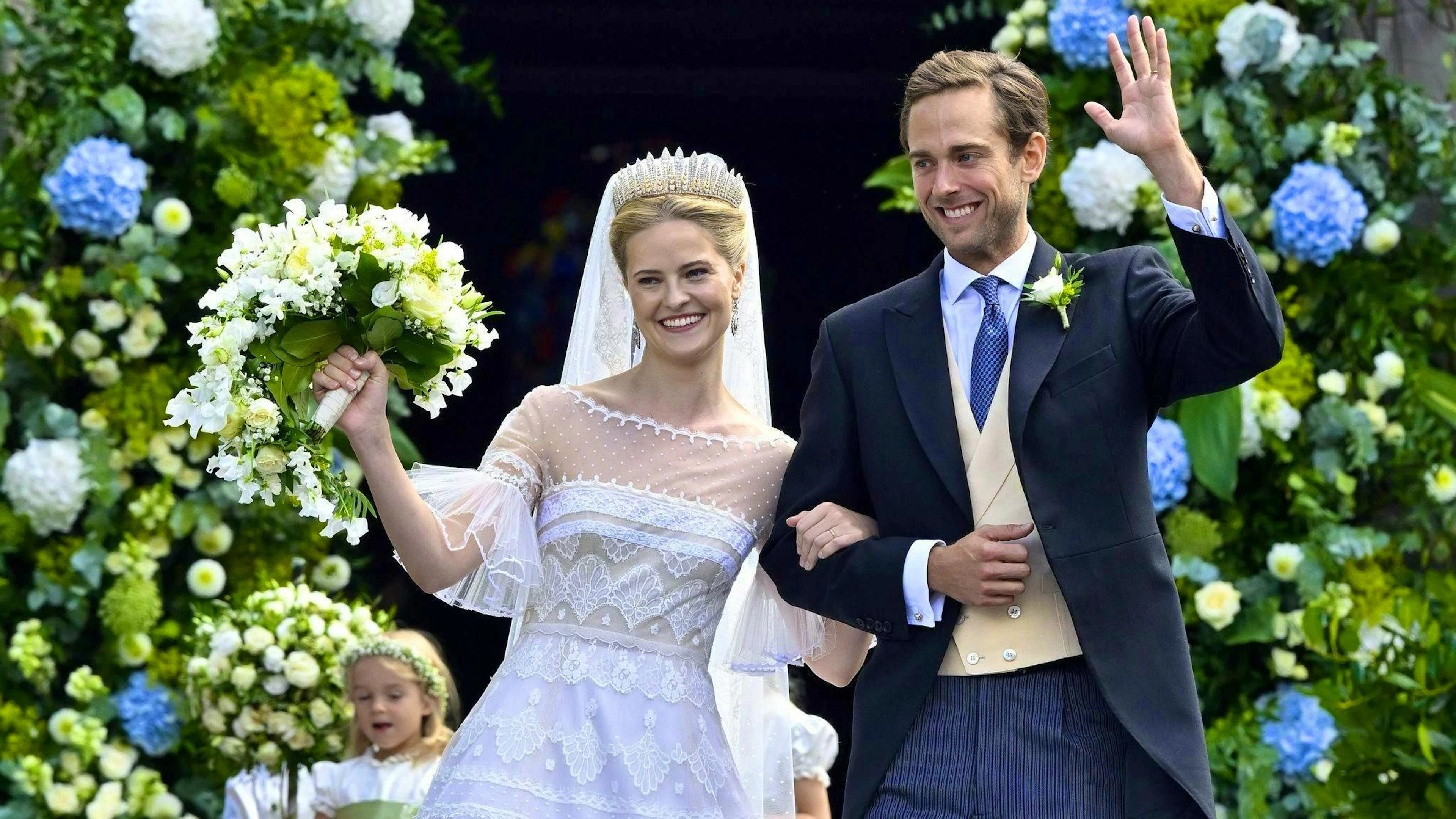 The bride wore a long white dress with embroidery and puffed sleeves.