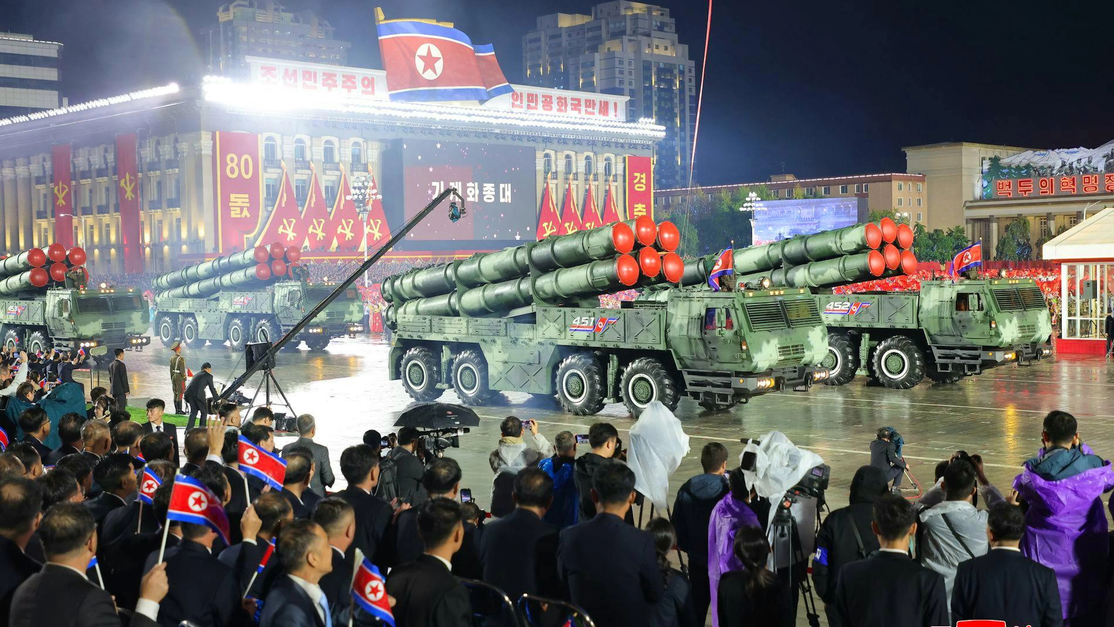 Des images diffusées par KCNA ont montré une série de longs missiles défiler à bord de véhicules, de nuit et sous une légère pluie.