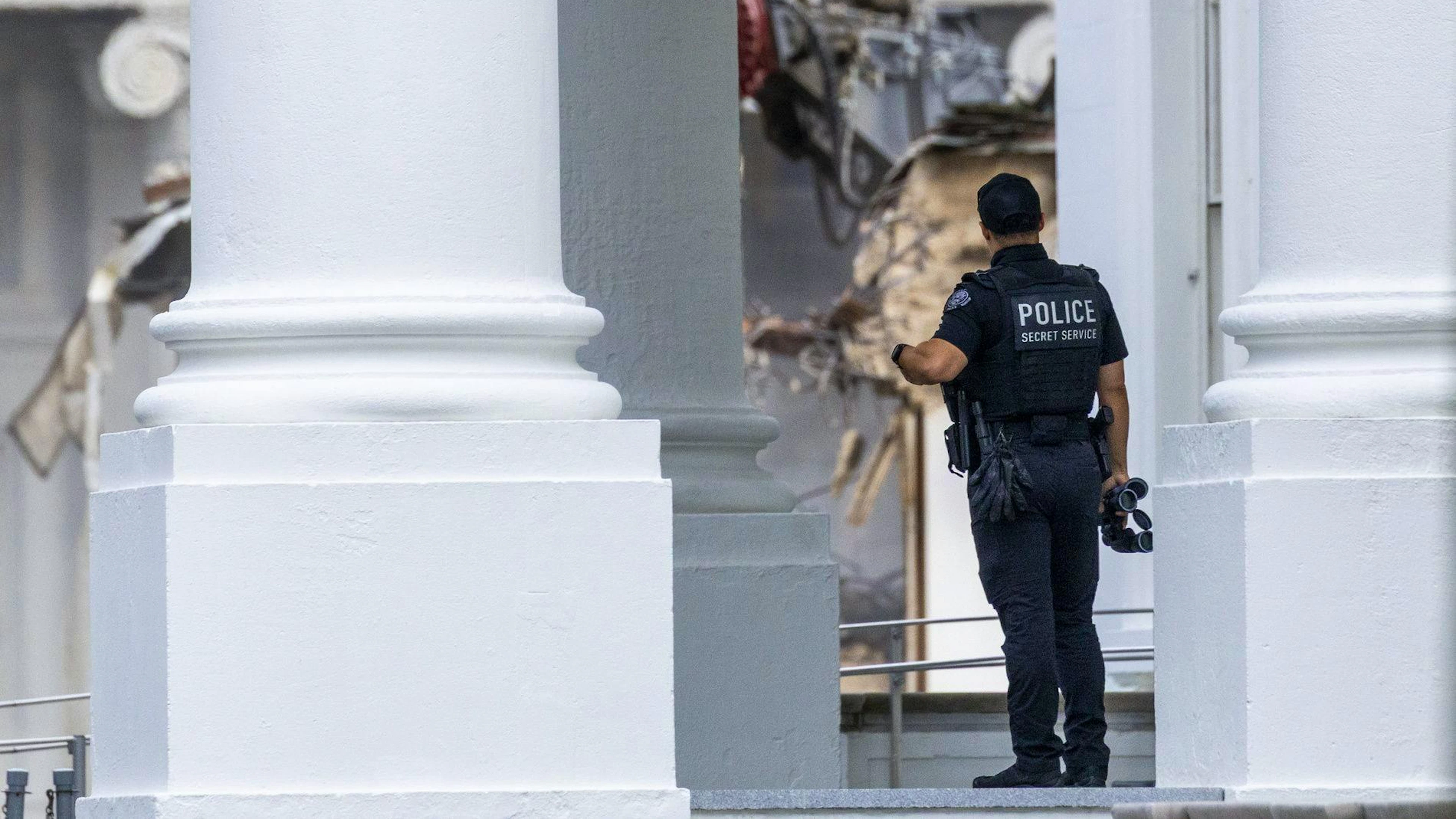 Ein Secret-Service-Beamter beobachtet die Demolierung des Ostflügels des Weissen Hauses, der mit privaten Spenden wieder aufgebaut werden soll. (22. Oktober 2025)