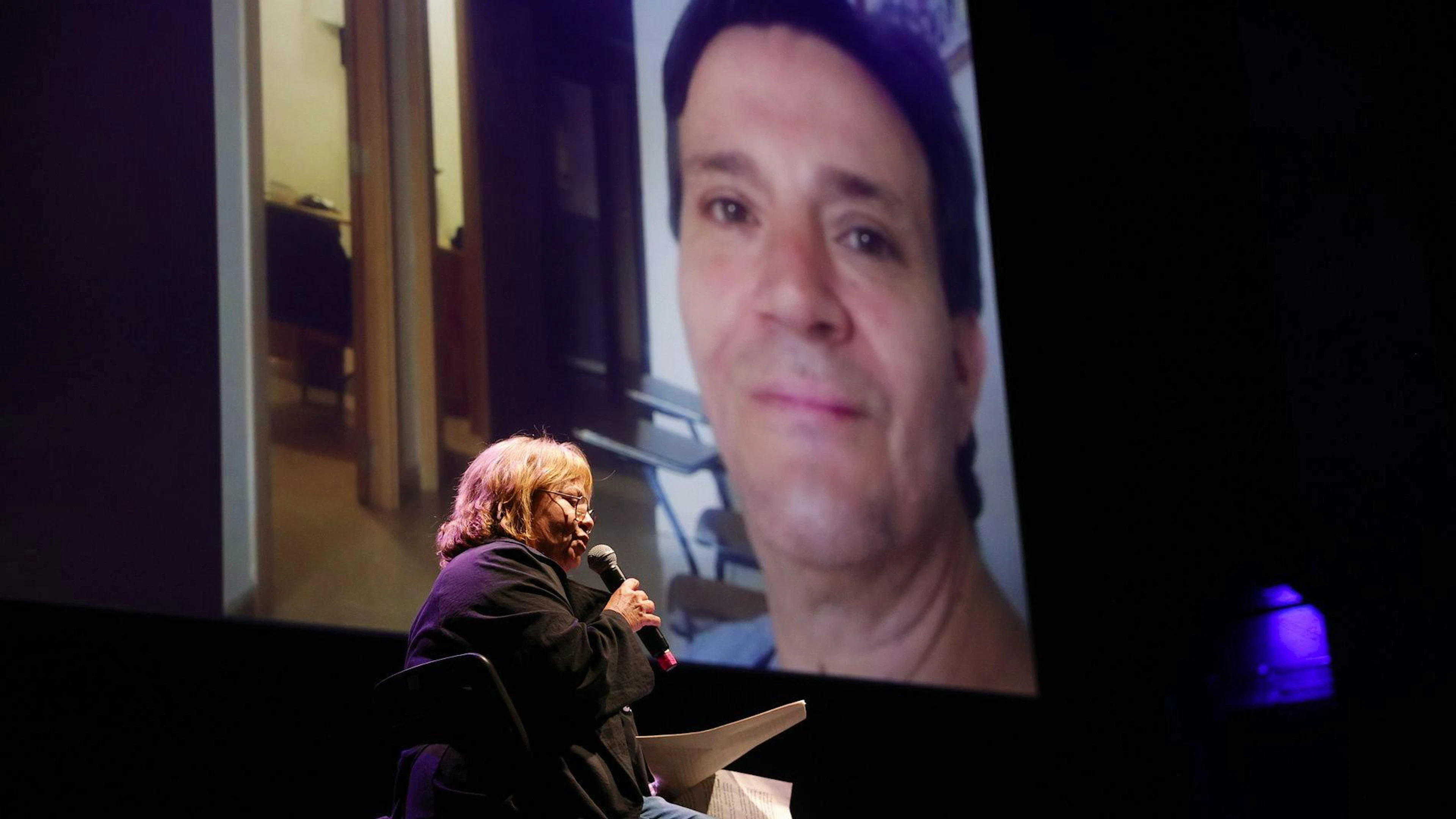 Des proches lisent des textes en mémoire des victimes lors d’un hommage organisé au théâtre Olympia de Valence, en Espagne, le 25 octobre 2025.