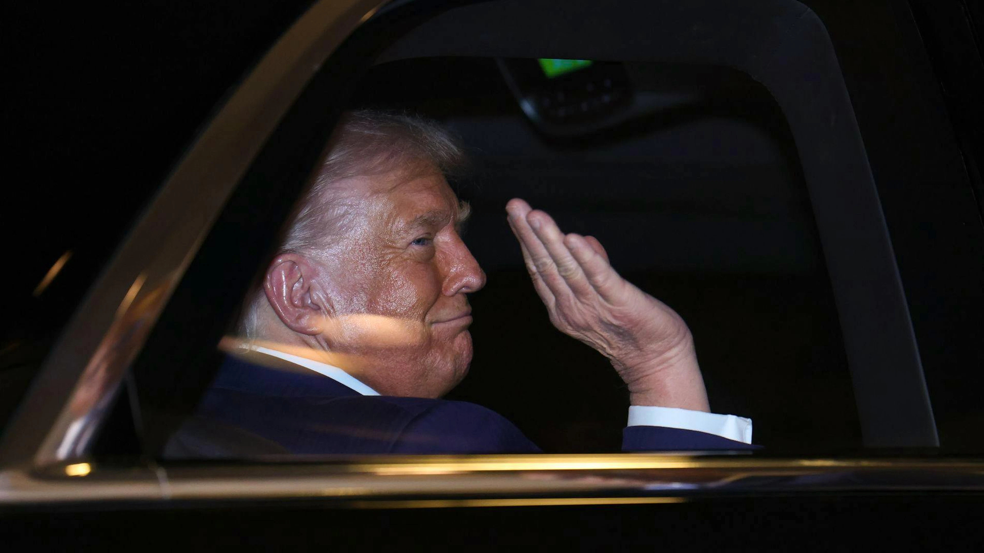 Donald Trump sulla limousine che lo ha portato al Palazzo imperiale di Tokyo.