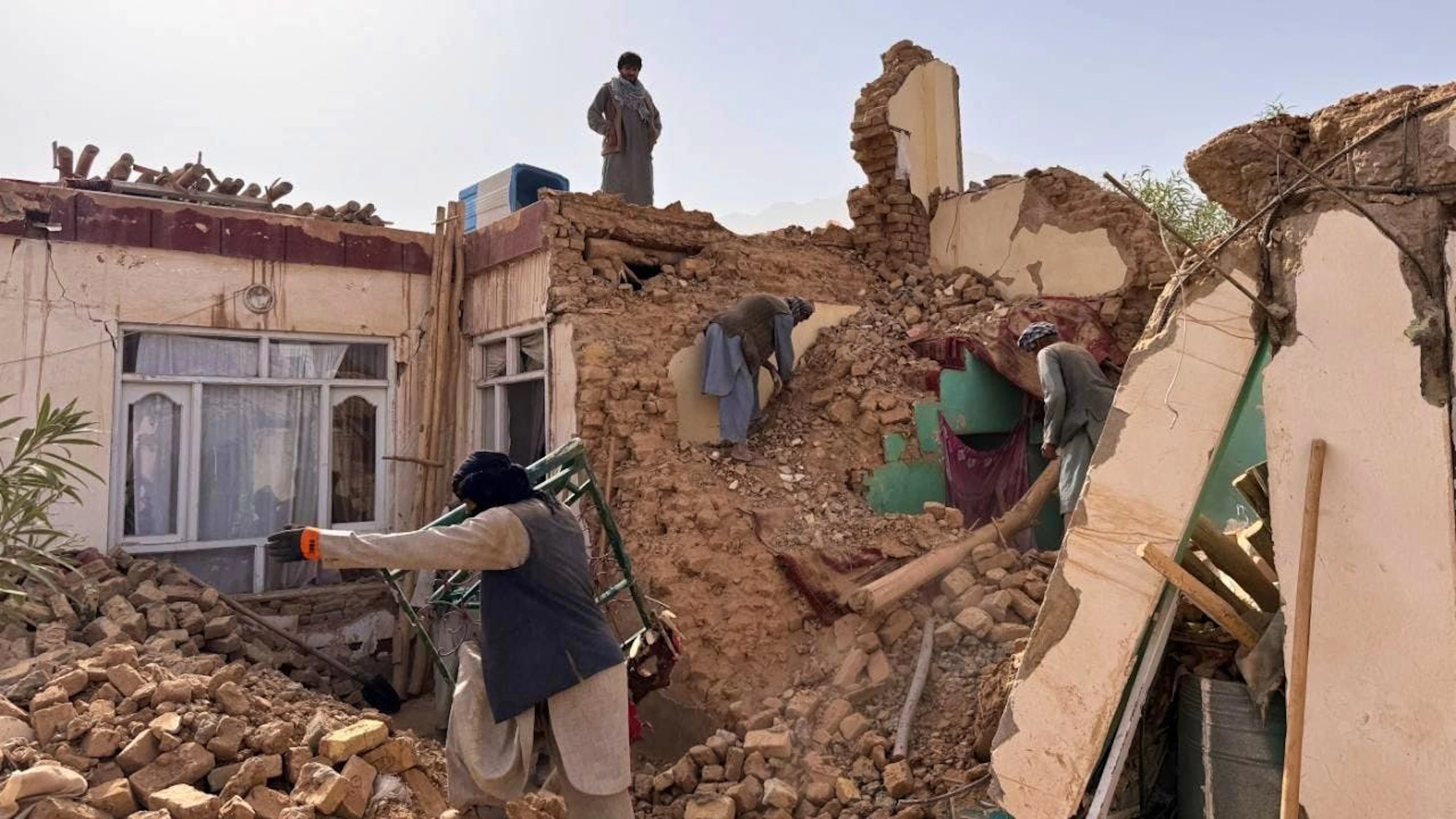 Einheimische suchen in den Trümmern eines zerstörten Hauses nach einem Erdbeben der Stärke 6,3 in einer ländlichen Gegend des Bezirks Khulm im Norden Afghanistans. Foto: Sirat Noori/AP/dpa