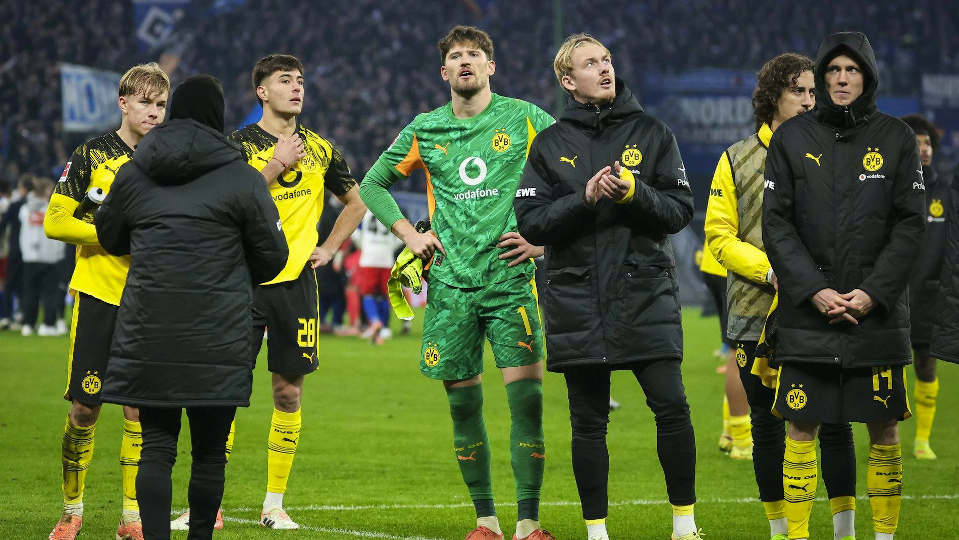 Gregor Kobel und weitere Spieler des BVB stehen nach dem Abpfiff vor der Dortmunder Fankurve.