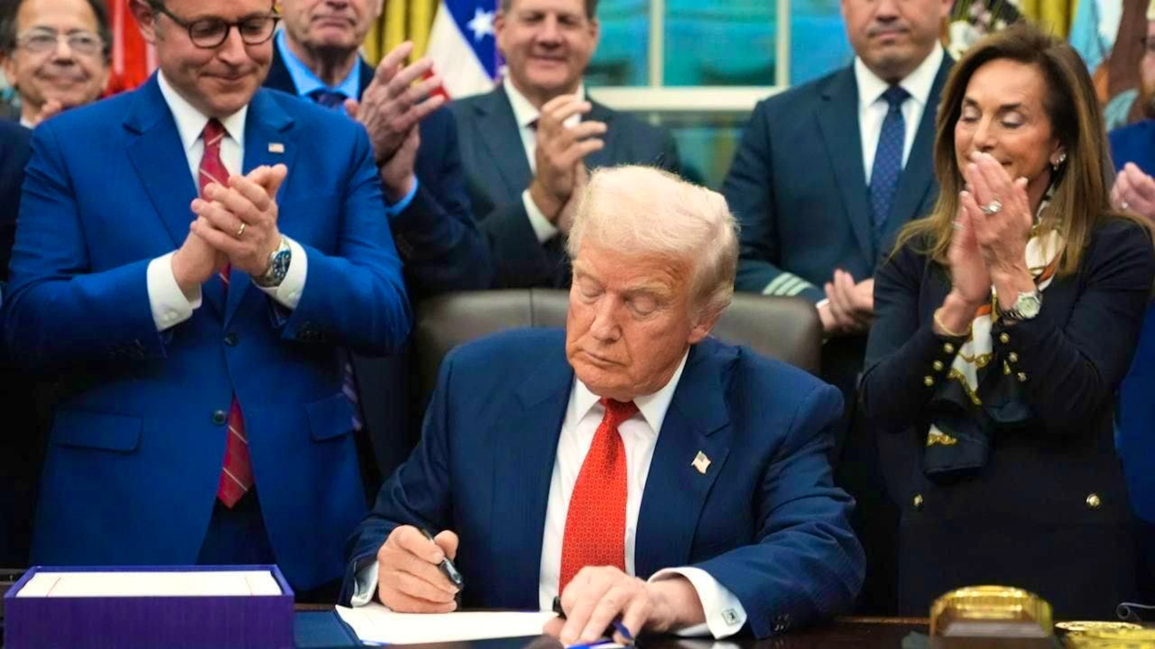 US President Donald Trump signs a legislative package to end the week-long partial shutdown of US government business. Photo: Jacquelyn Martin/AP/dpa