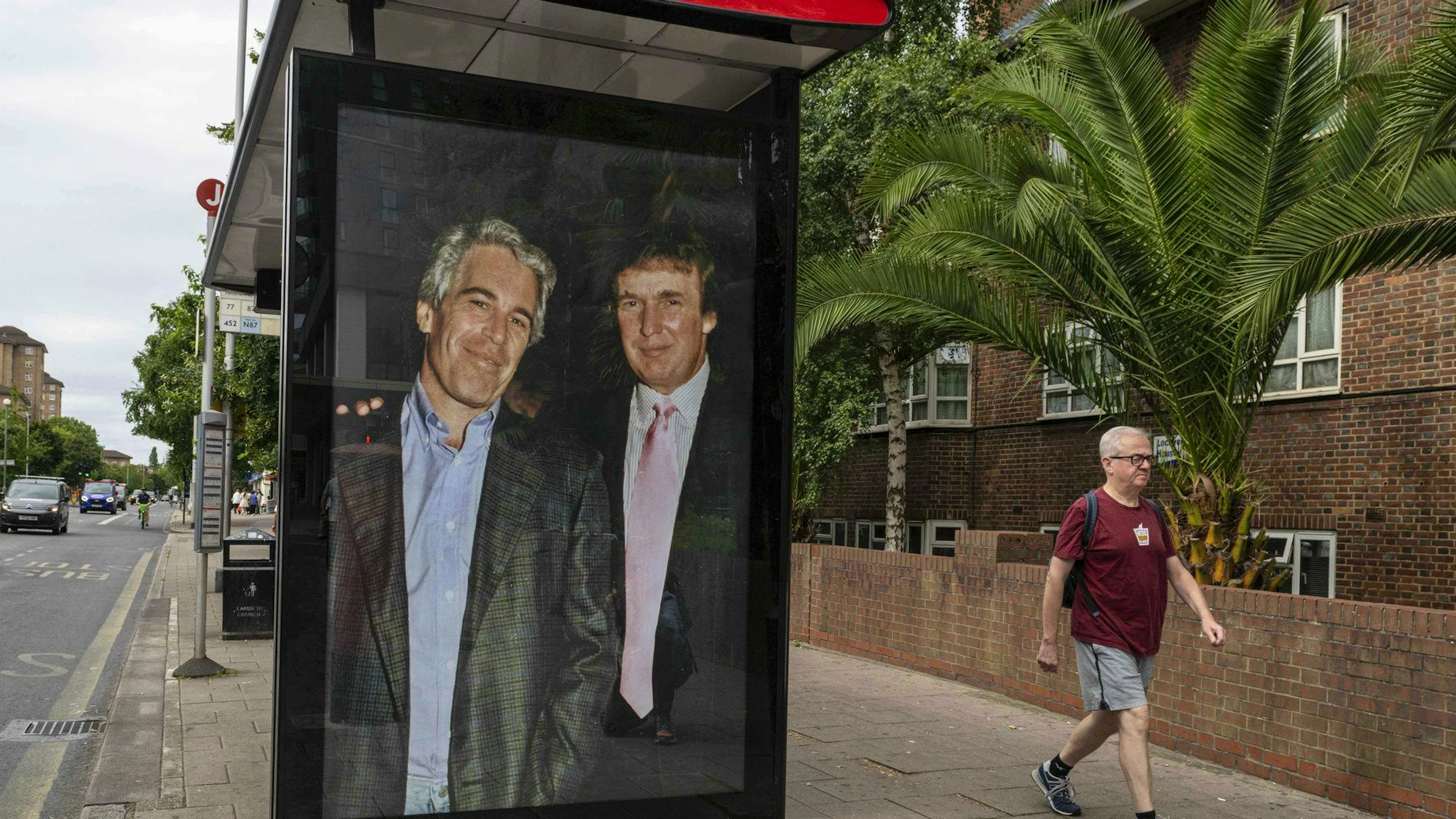 Degli attivisti affiggono un manifesto che ritrae il presidente Donald Trump e Jeffrey Epstein.