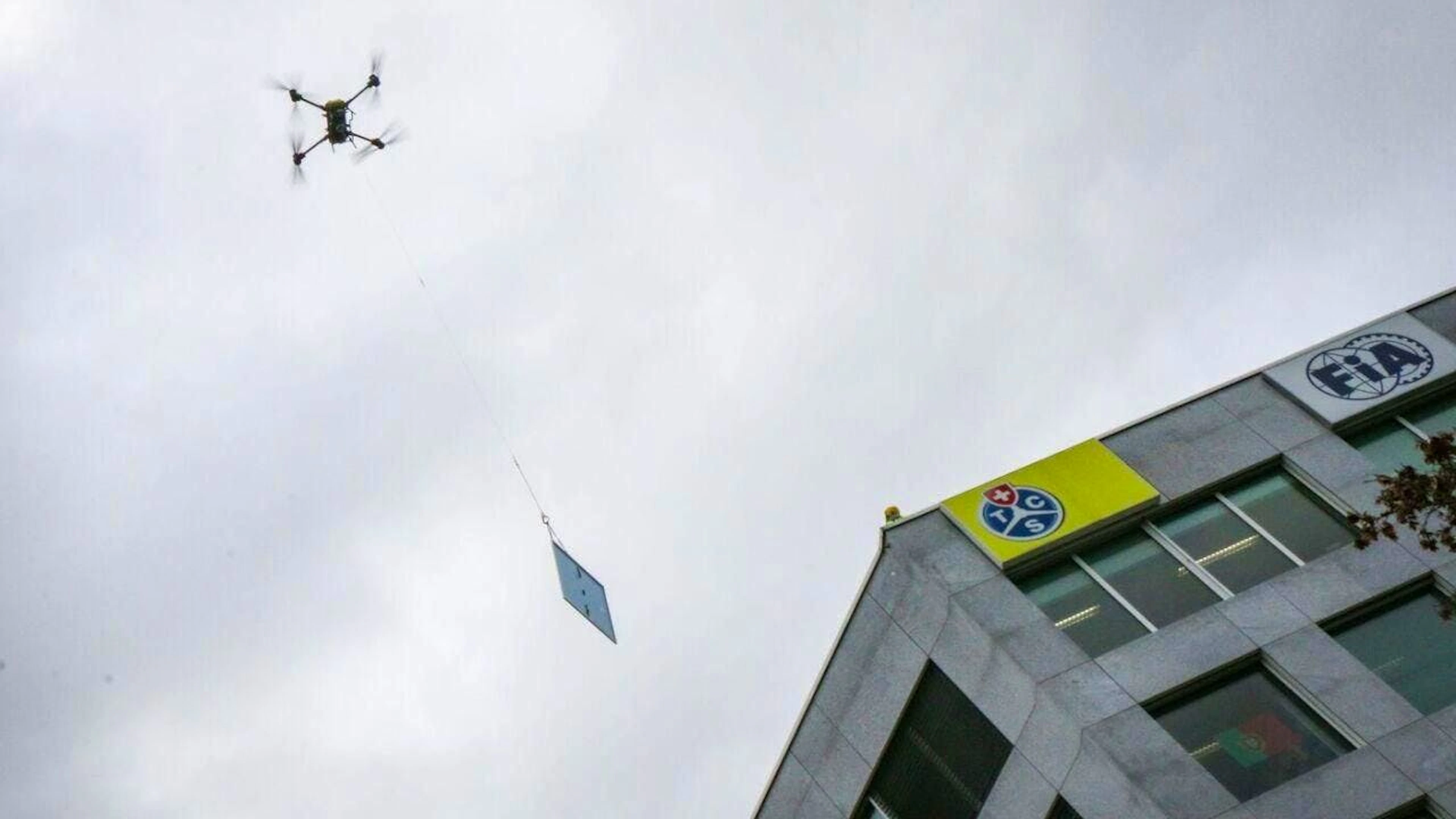 Eine Lastendrohne von TCS Drops fliegt ein Solarpanel auf das Dach des TCS-Hauptsitzes in Vernier GE.