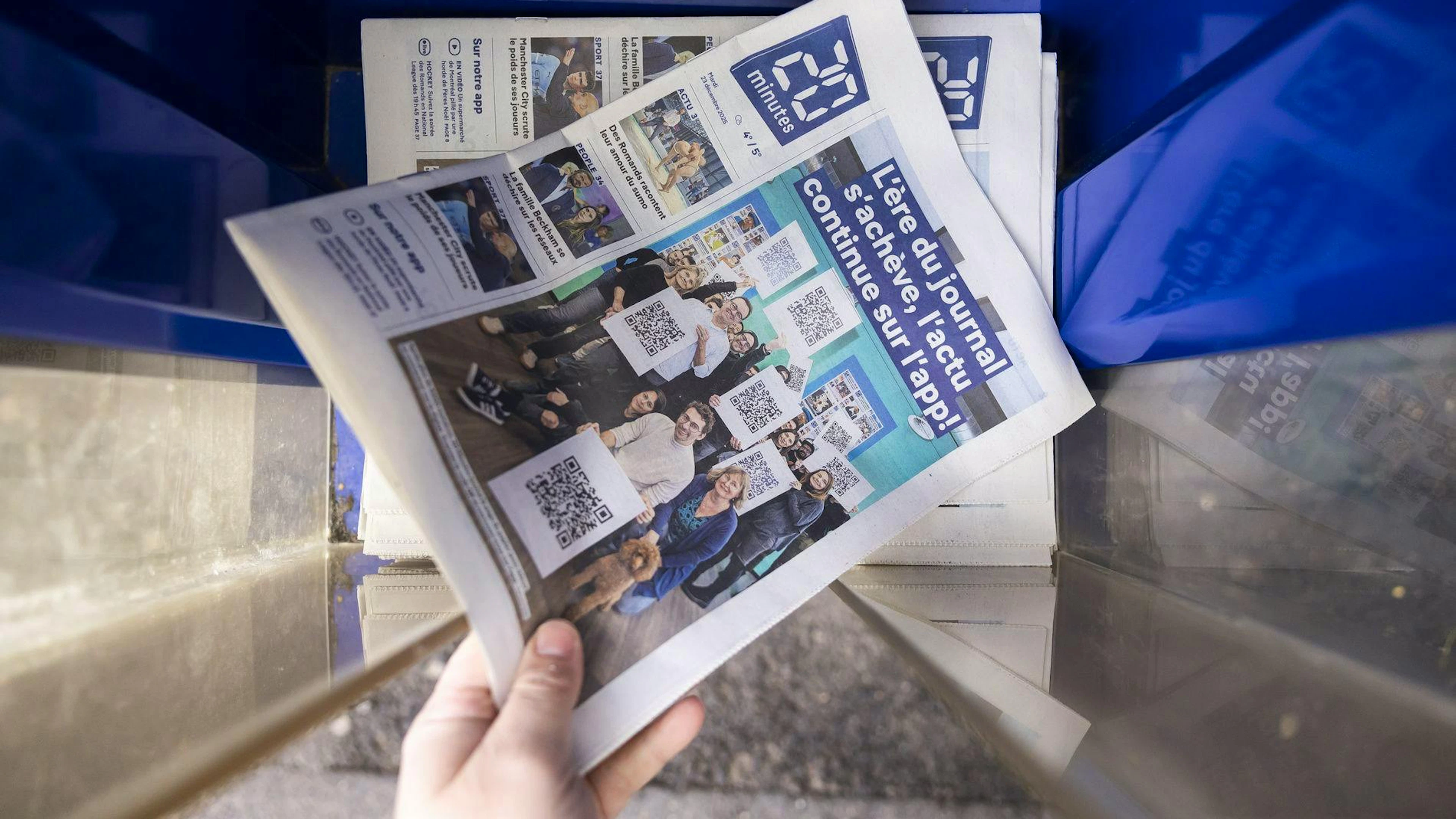La derniere edition du journal papier de "20 minutes" est photographiee ce mardi 23 decembre 2025 dans une boite a journaux de Vevey. En juin 2025, l'editeur TX-Group avait annonce l'arret de la publication de la version papier de "20 minutes" afin d'accelerer sa transition numérique. (KEYSTONE/Cyril Zingaro)