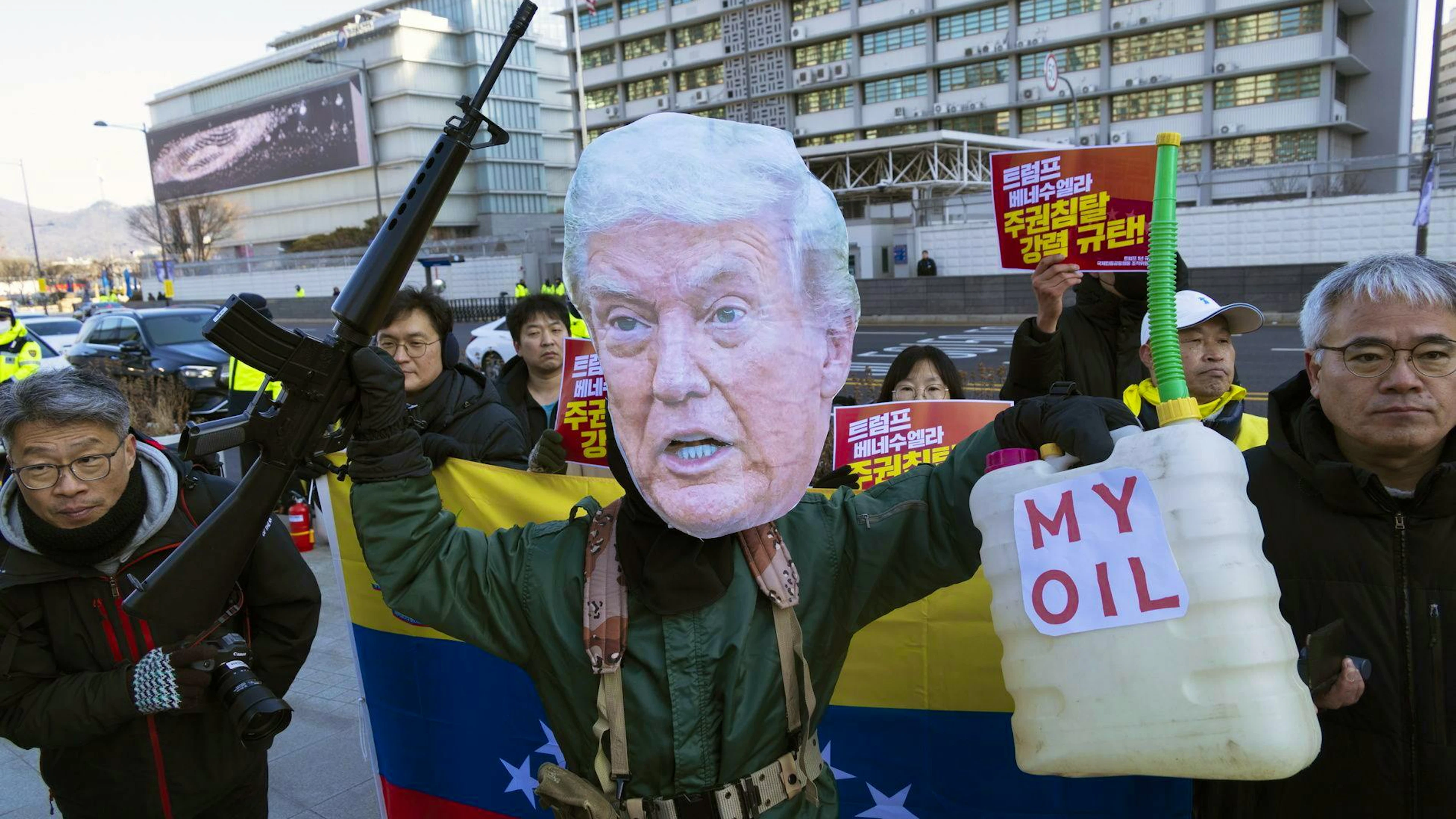 Un manifestant portant un masque à l'effigie du président américain Donald Trump se produit tandis que des manifestants scandent des slogans lors d'une manifestation contre le président américain Donald Trump et les actions militaires américaines au Venezuela, devant l'ambassade américaine à Séoul, en Corée du Sud, le 5 janvier 2026.