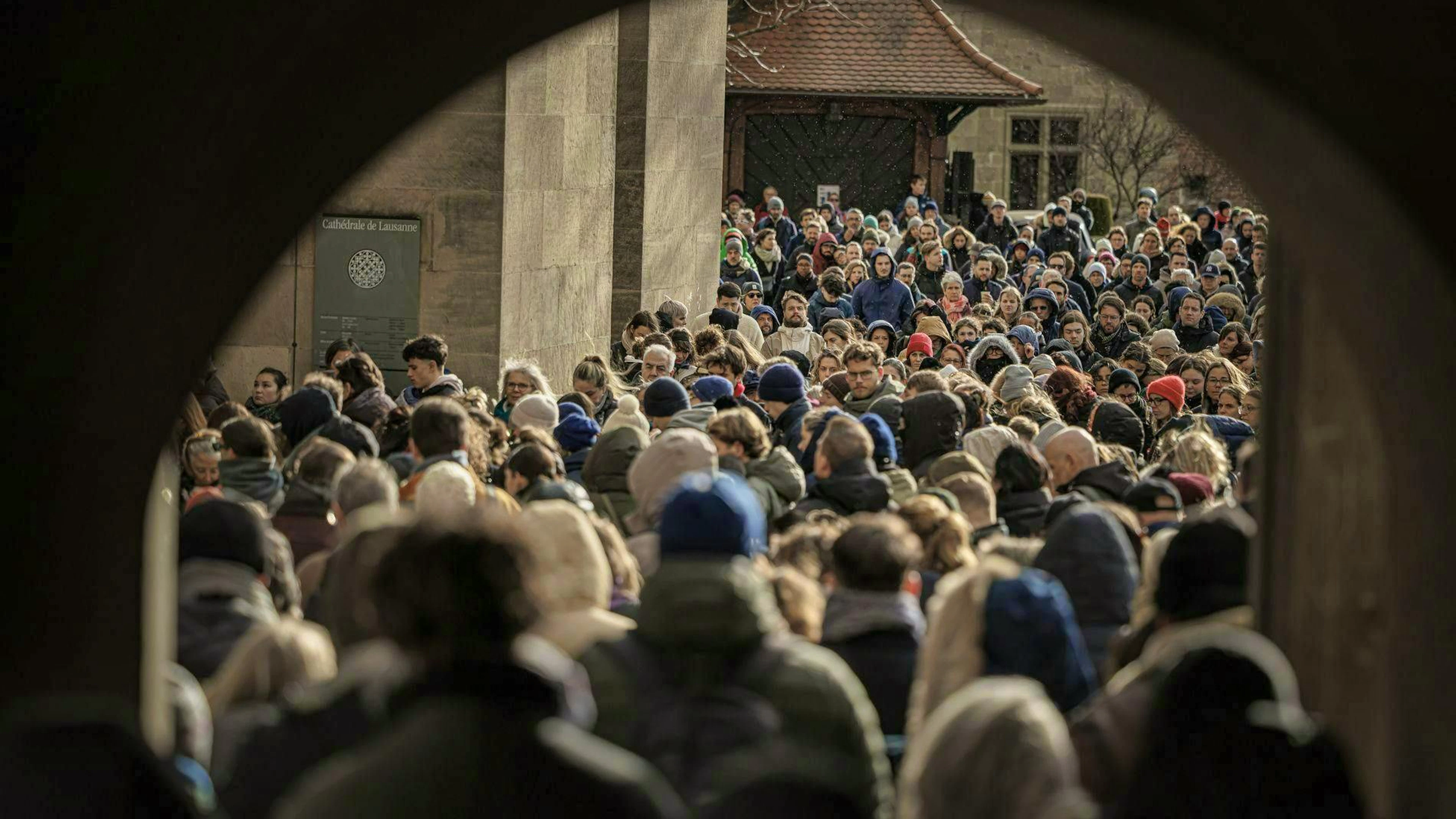 Numerous people gather in front of the cathedral in Lausanne.