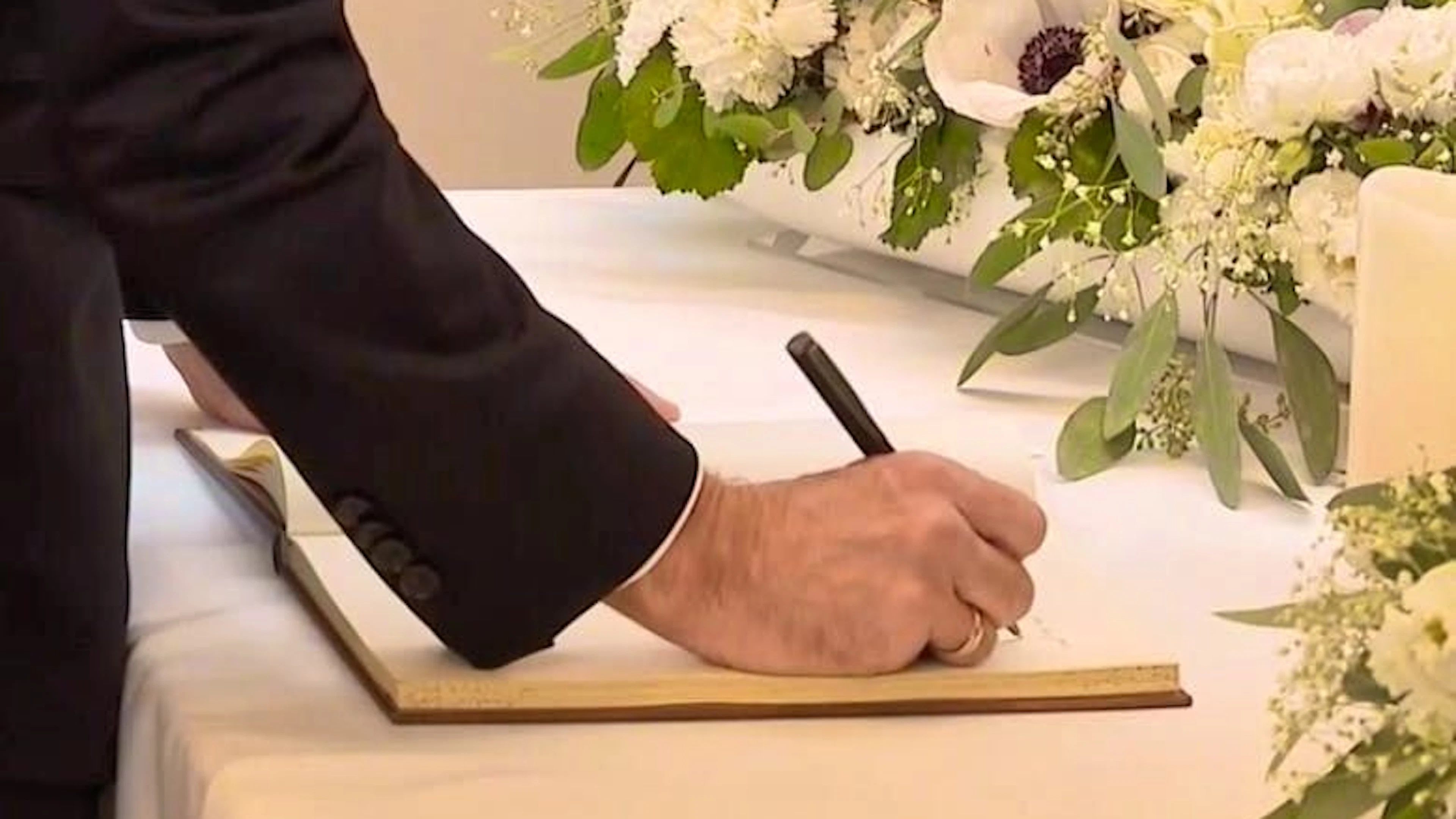 Emmanuel Macron writes in the book of condolence. 