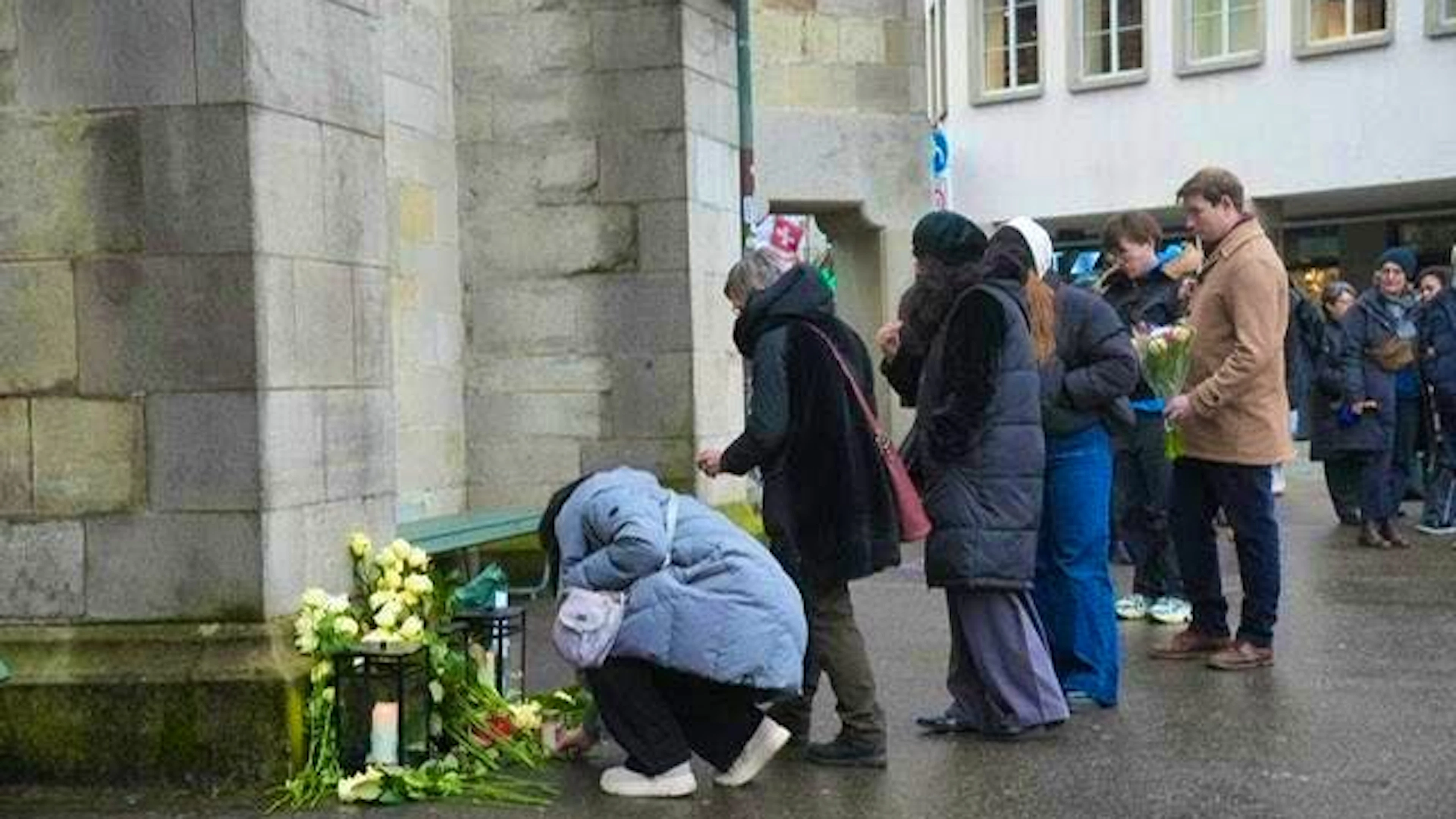 Passers-by lay flowers in front of Zurich's Fraumünster church.