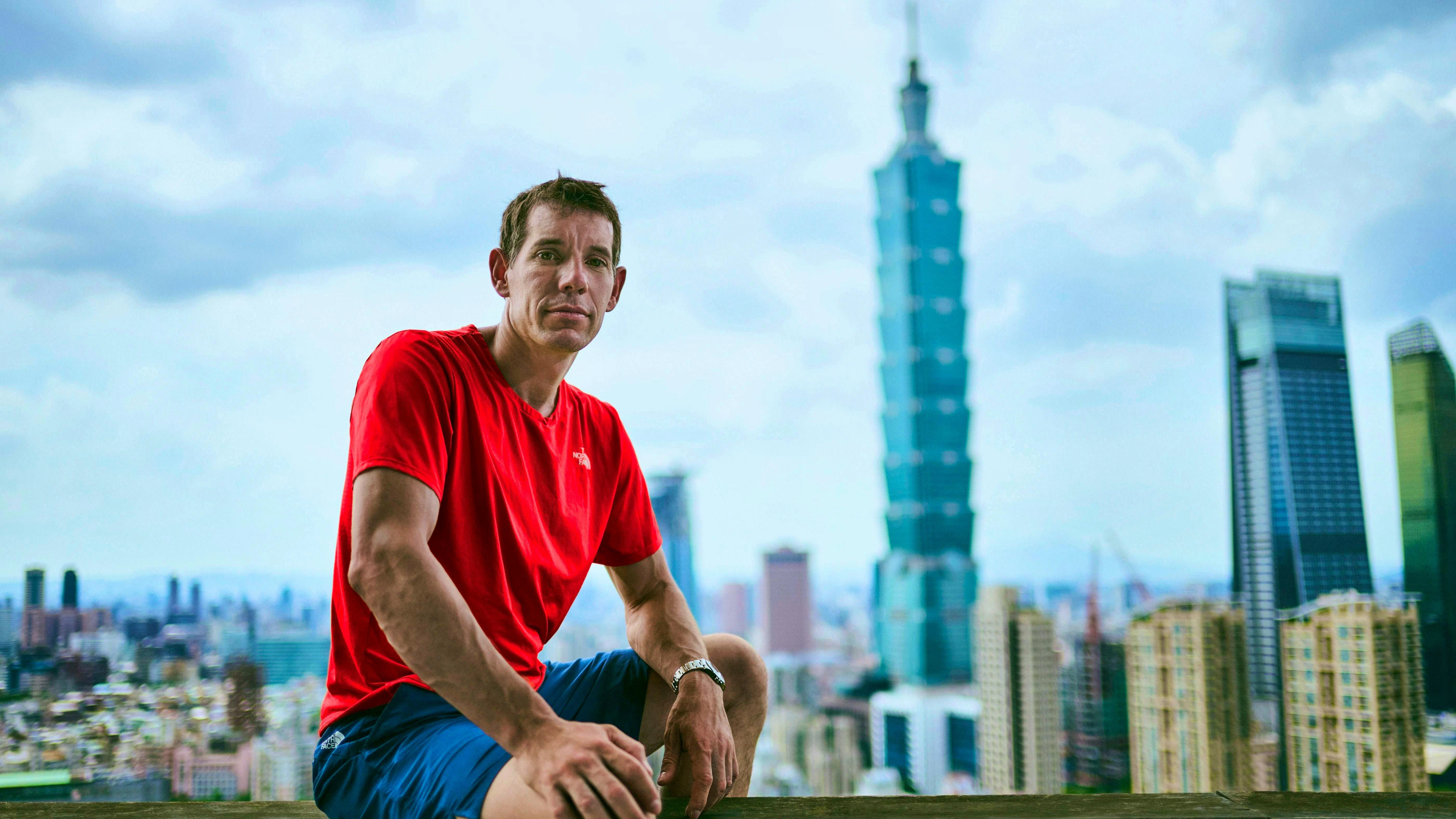 Alex Honnold à Taipei, Taïwan. En arrière-plan, la tour qu'il escaladera le 23 janvier.