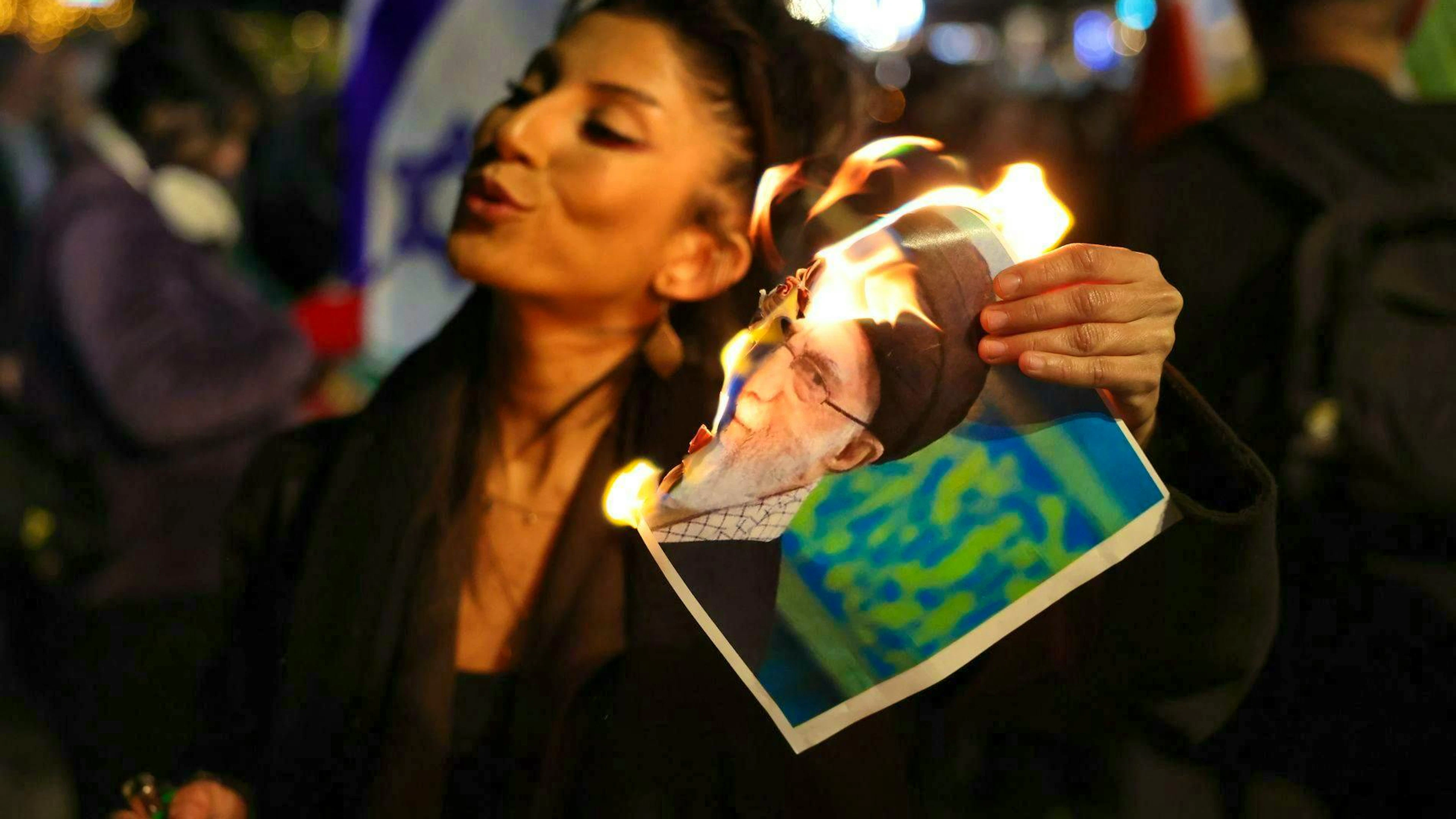 At a protest rally in Holon, Israel, a member of the Israeli-Iranian community burns a portrait of Iran's Supreme Leader Ali Khamenei.