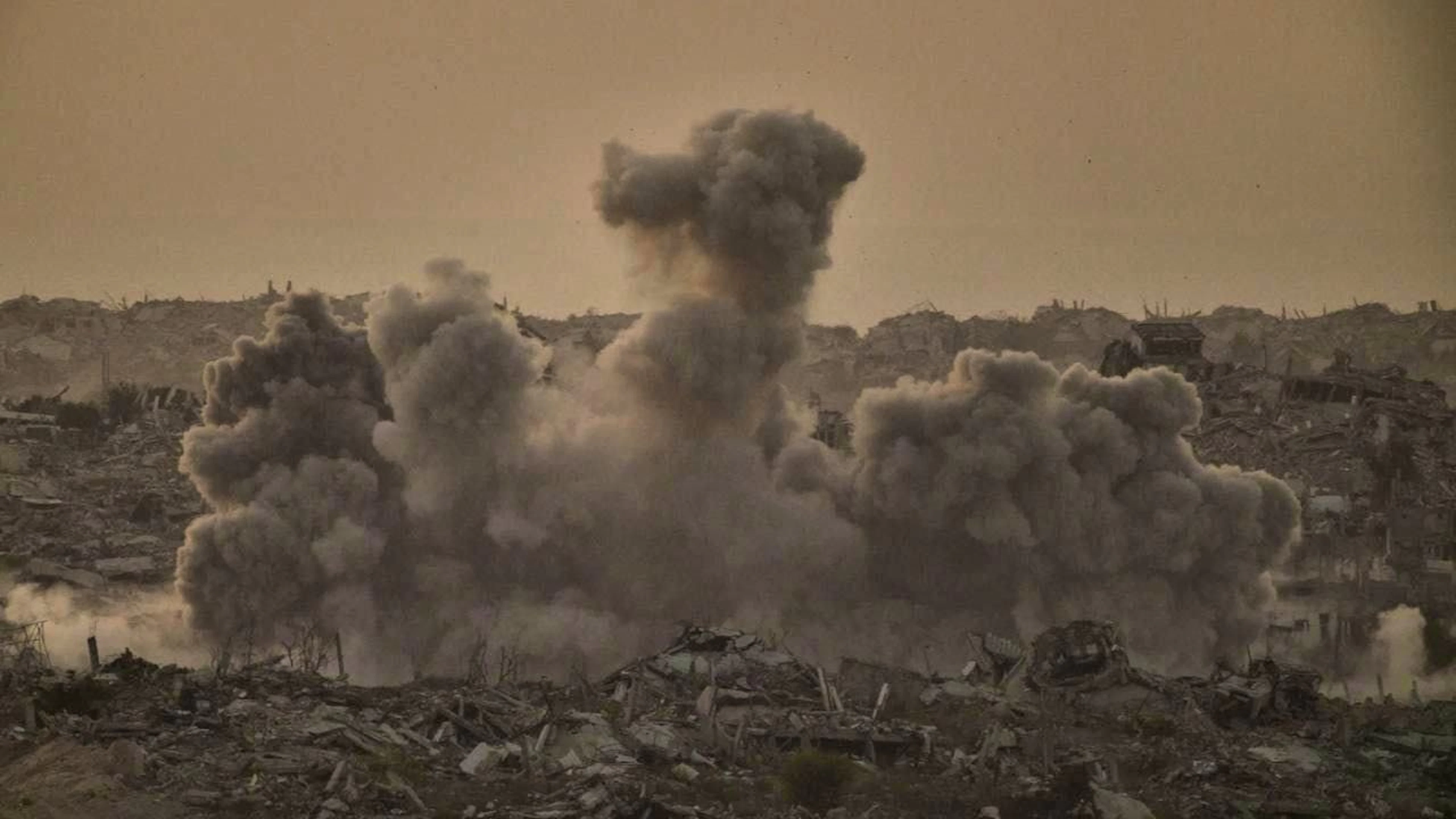 ARCHIVE - Buildings destroyed in Israeli ground and air strikes are shrouded in smoke after an Israeli military strike in the northern Gaza Strip, as seen from southern Israel. Photo: Leo Correa/AP/dpa