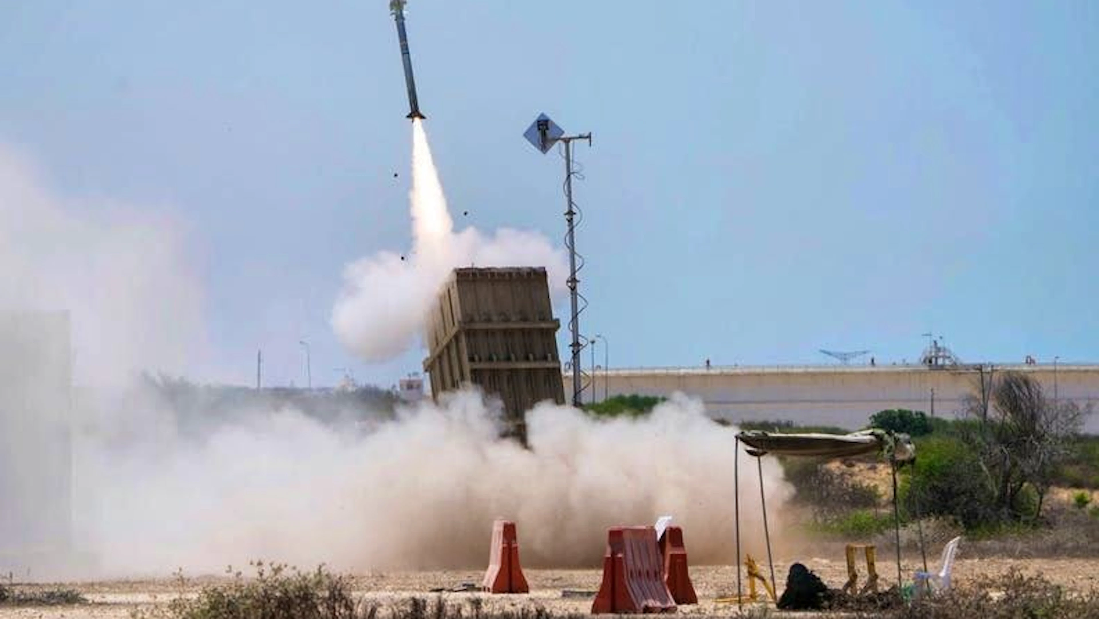 Un soldato israeliano si ripara vicino ad Ashkelon mentre il sistema di difesa missilistico israeliano «Iron Dome» si lancia per intercettare un razzo sparato dalla Striscia di Gaza. Israele ha mobilitato 70.000 riservisti per l'operazione contro l'Iran.