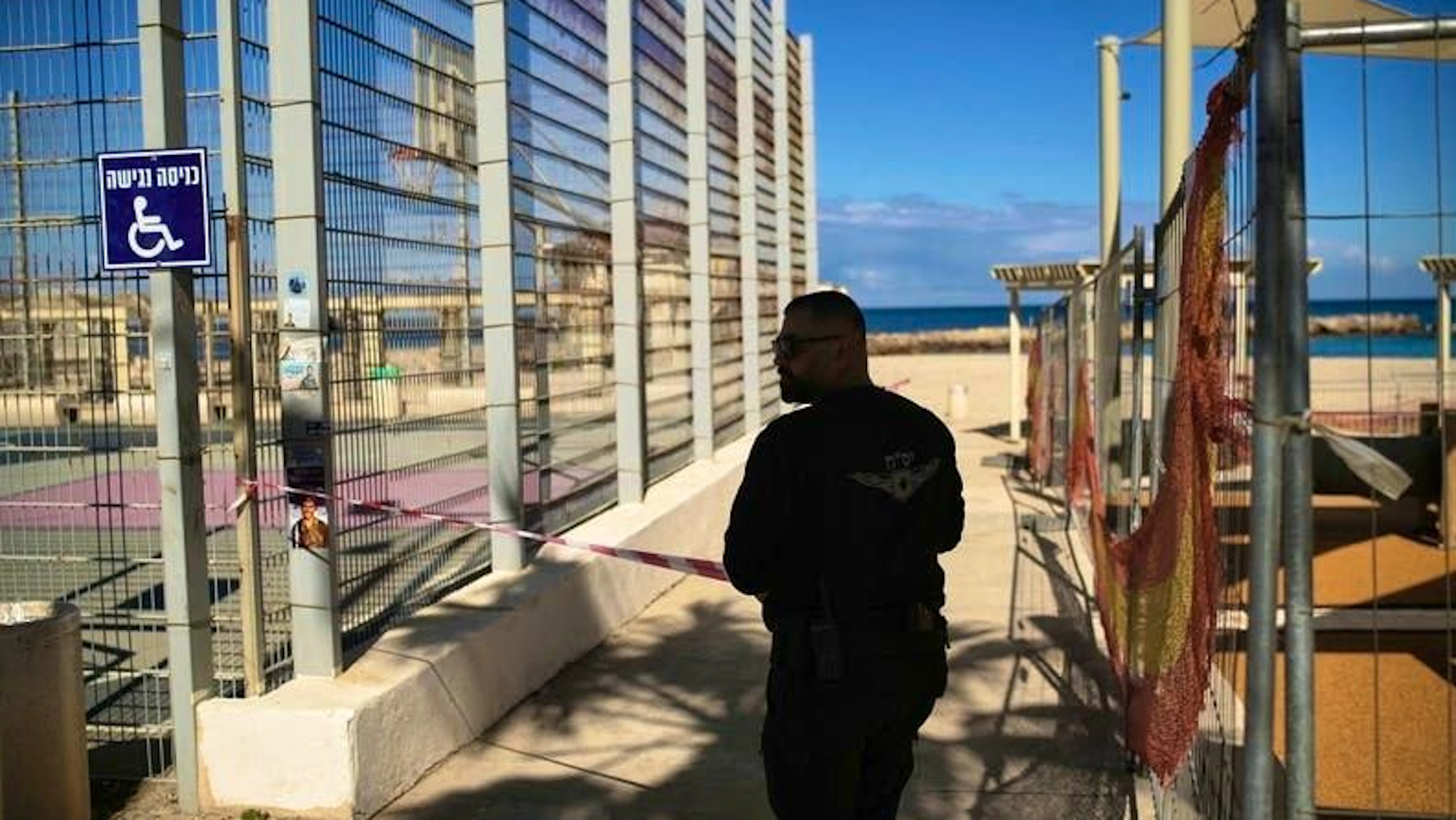 Un agente di polizia delimita il lungomare di Haifa dopo il suono delle sirene nella città portuale.