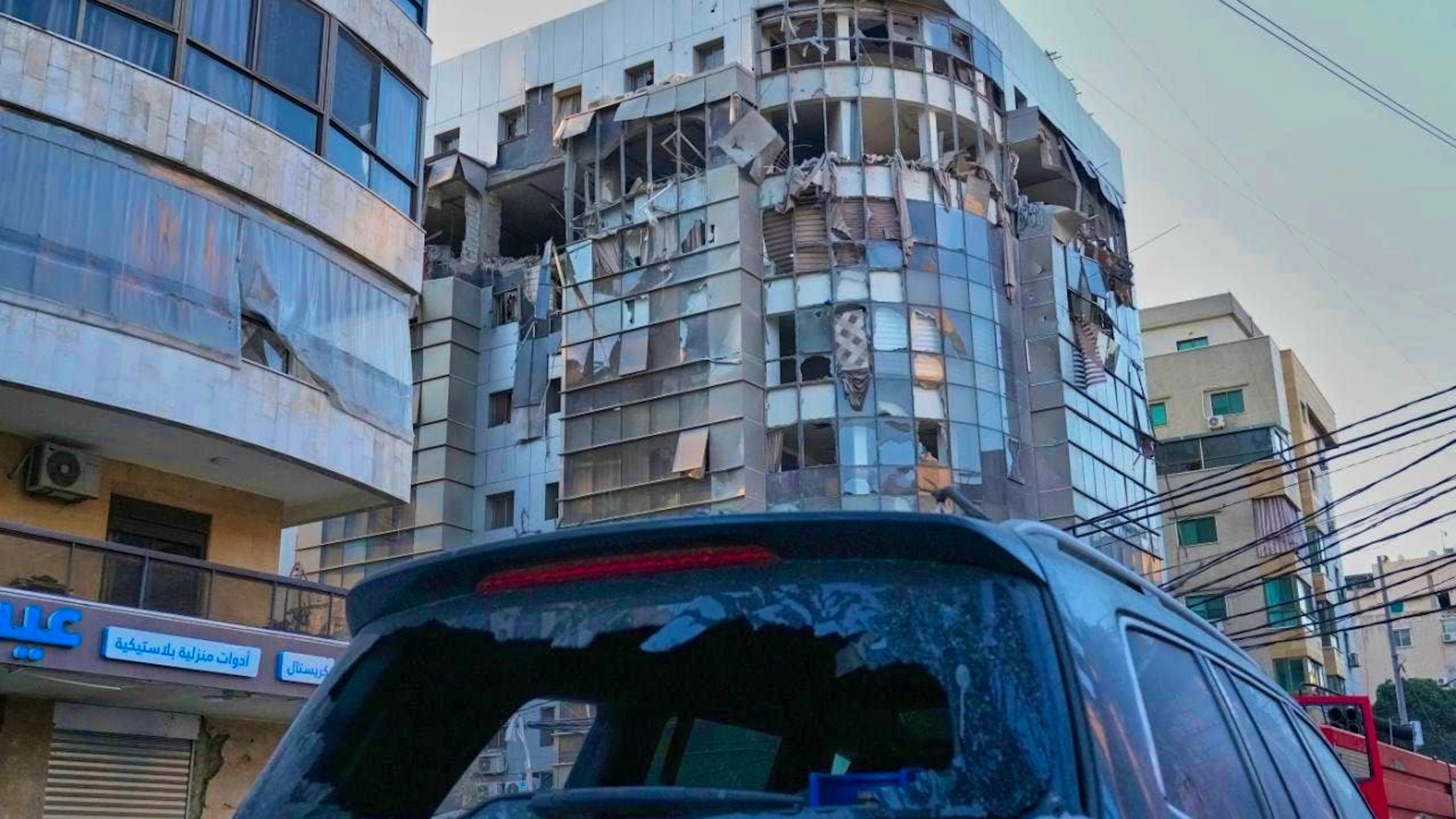 A damaged car stands in front of a house that was hit by an Israeli airstrike. Photo: Hussein Malla/AP/dpa