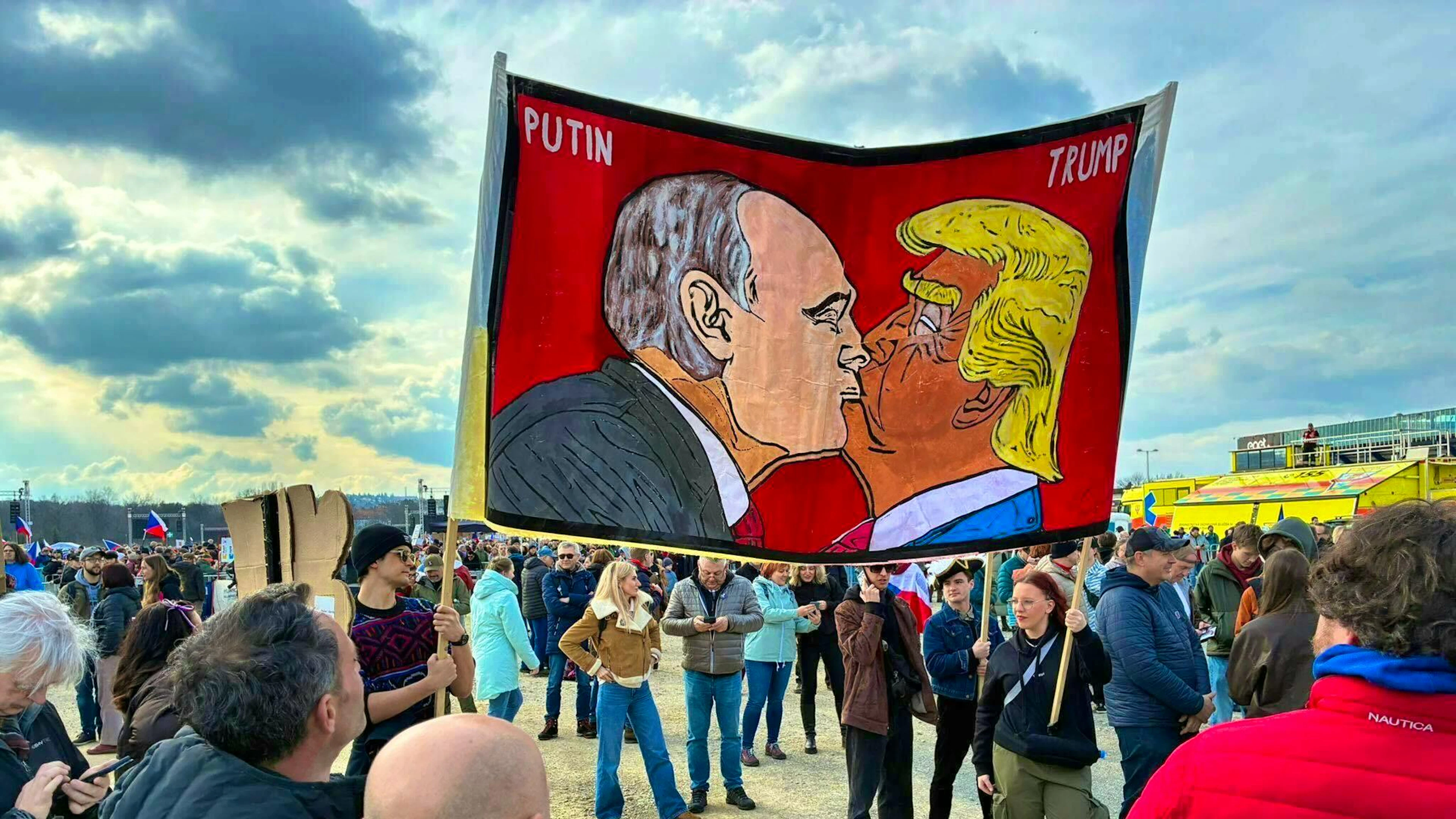 Demonstrators hold a banner with a stylized kiss between US President Trump and Russian President Putin at a rally organized by the "One Million Moments for Democracy" alliance.