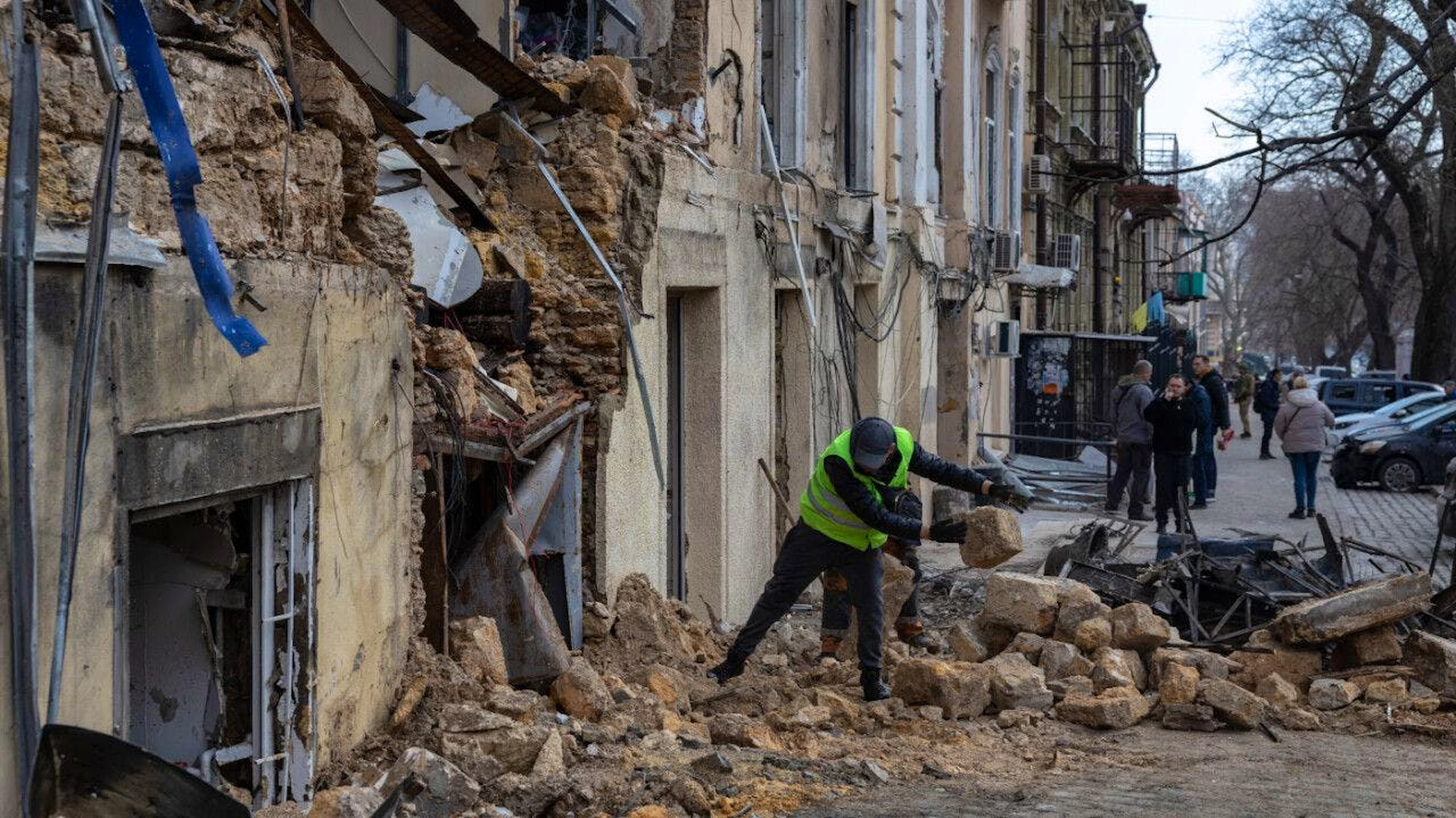 ARCHIV - Ein städtischer Arbeiter räumt die Trümmer eines Wohnhauses auf, das nach einem russischen Drohnenangriff beschädigt wurde. Foto: Oleg Grekov/AP/dpa
