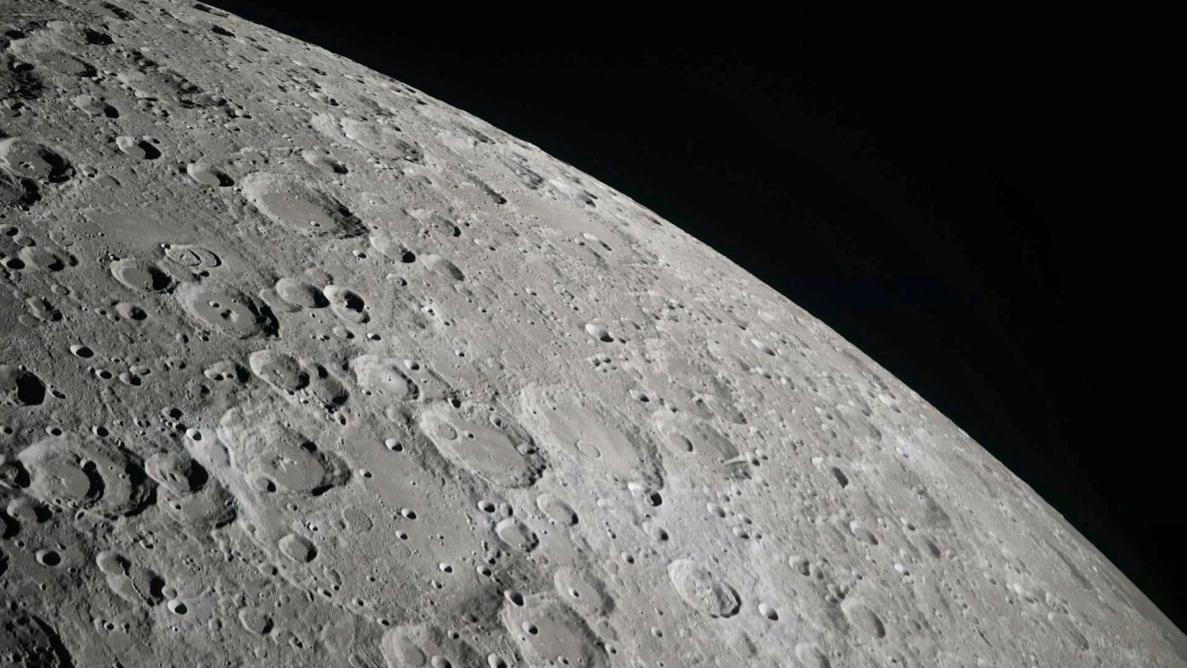 During a flyby observation of the moon, the crew of Artemis II captured the craters that dot the lunar surface, providing a glimpse of its rugged, ancient surface. This scarred landscape bears witness to a long history of cosmic collisions.