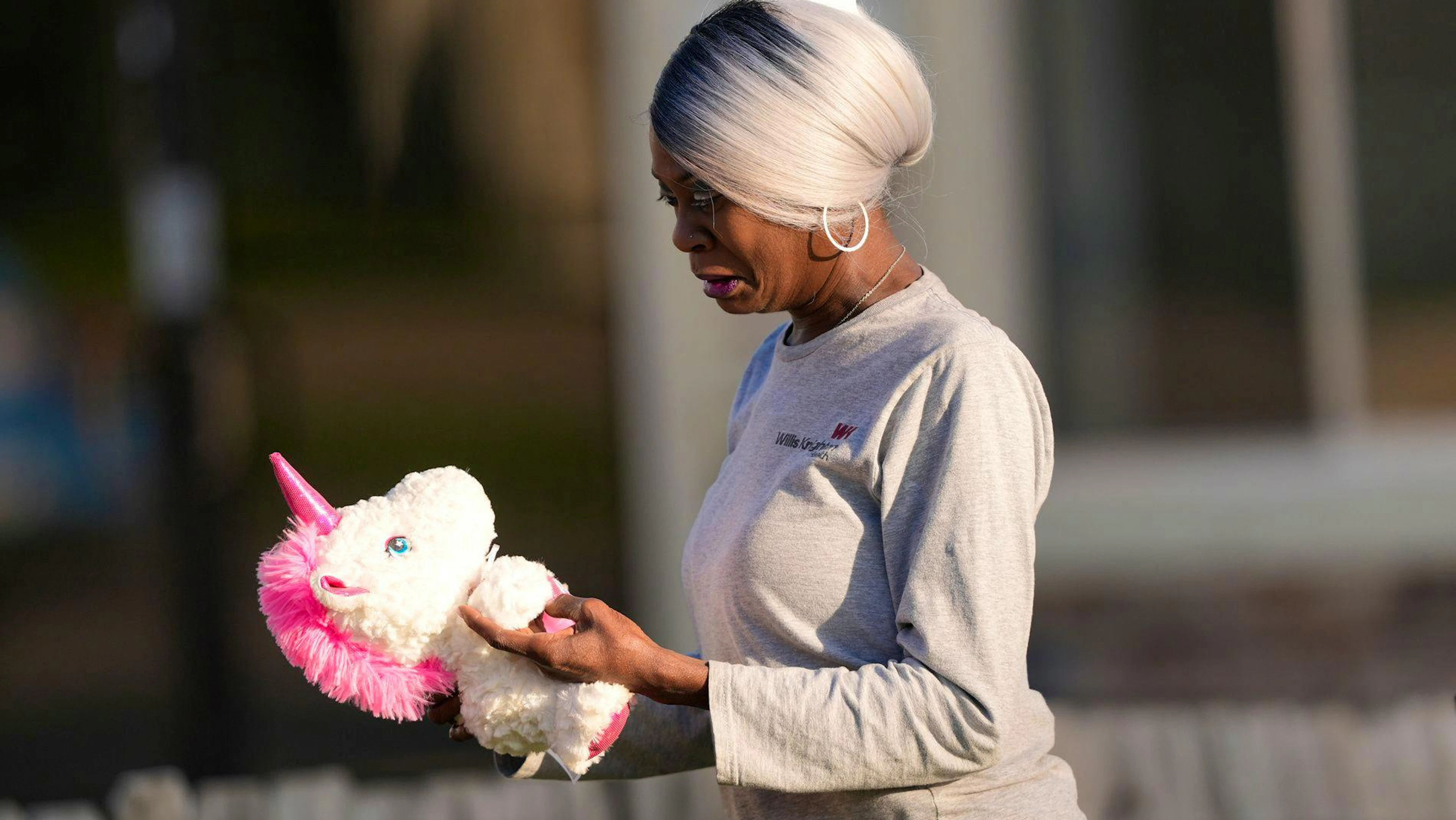 Une femme tient une peluche en forme de licorne à son arrivée sur les lieux d'une fusillade de masse, le dimanche 19 avril 2026, à Shreveport, en Louisiane. (Photo AP/Gerald Herbert)