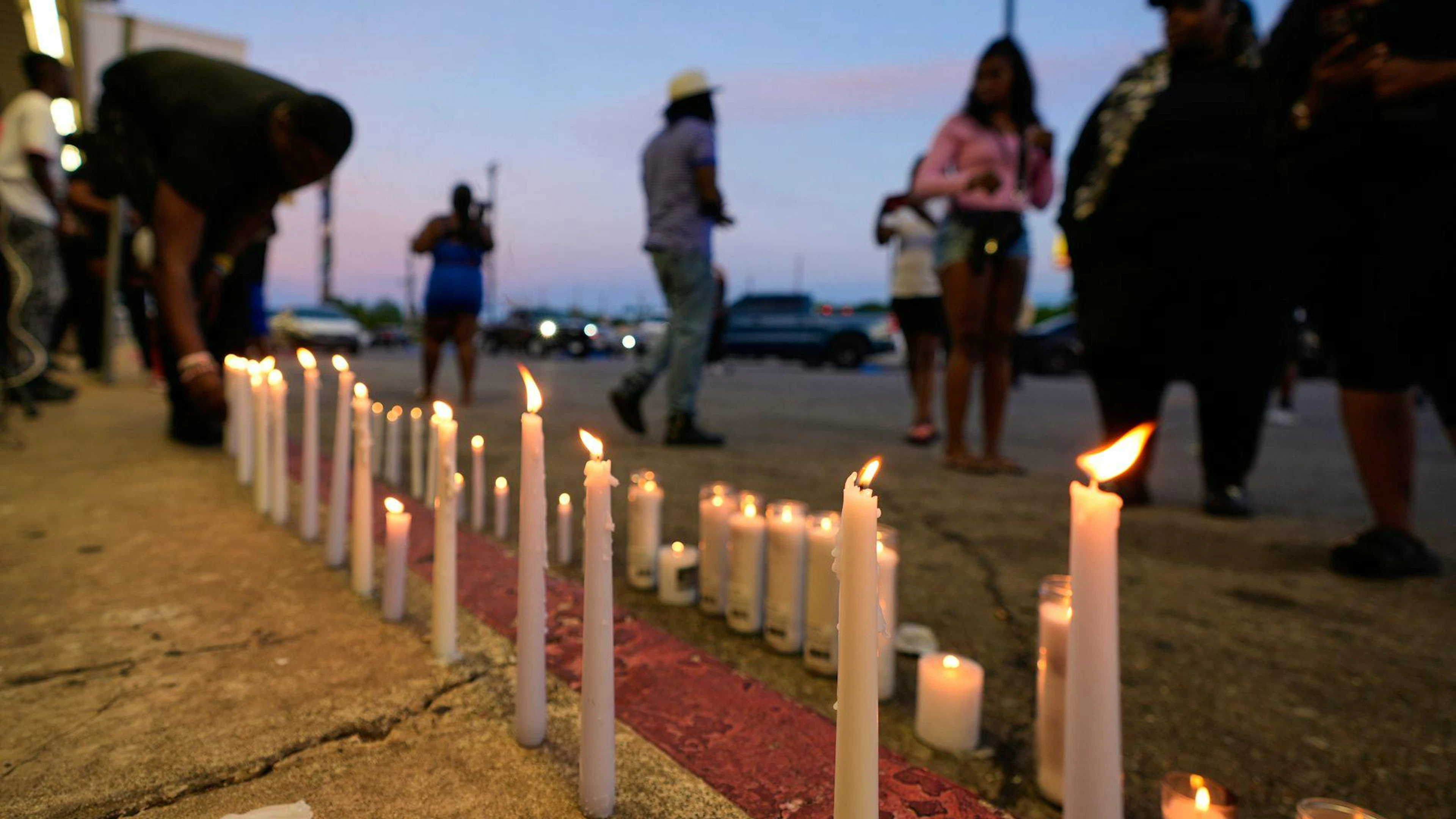 Un homme allume une bougie lors d'une veillée de prière en hommage aux victimes d'une fusillade de masse survenue plus tôt dans la journée, le dimanche 19 avril 2026, à Shreveport, en Louisiane. (AP Photo/Gerald Herbert)
