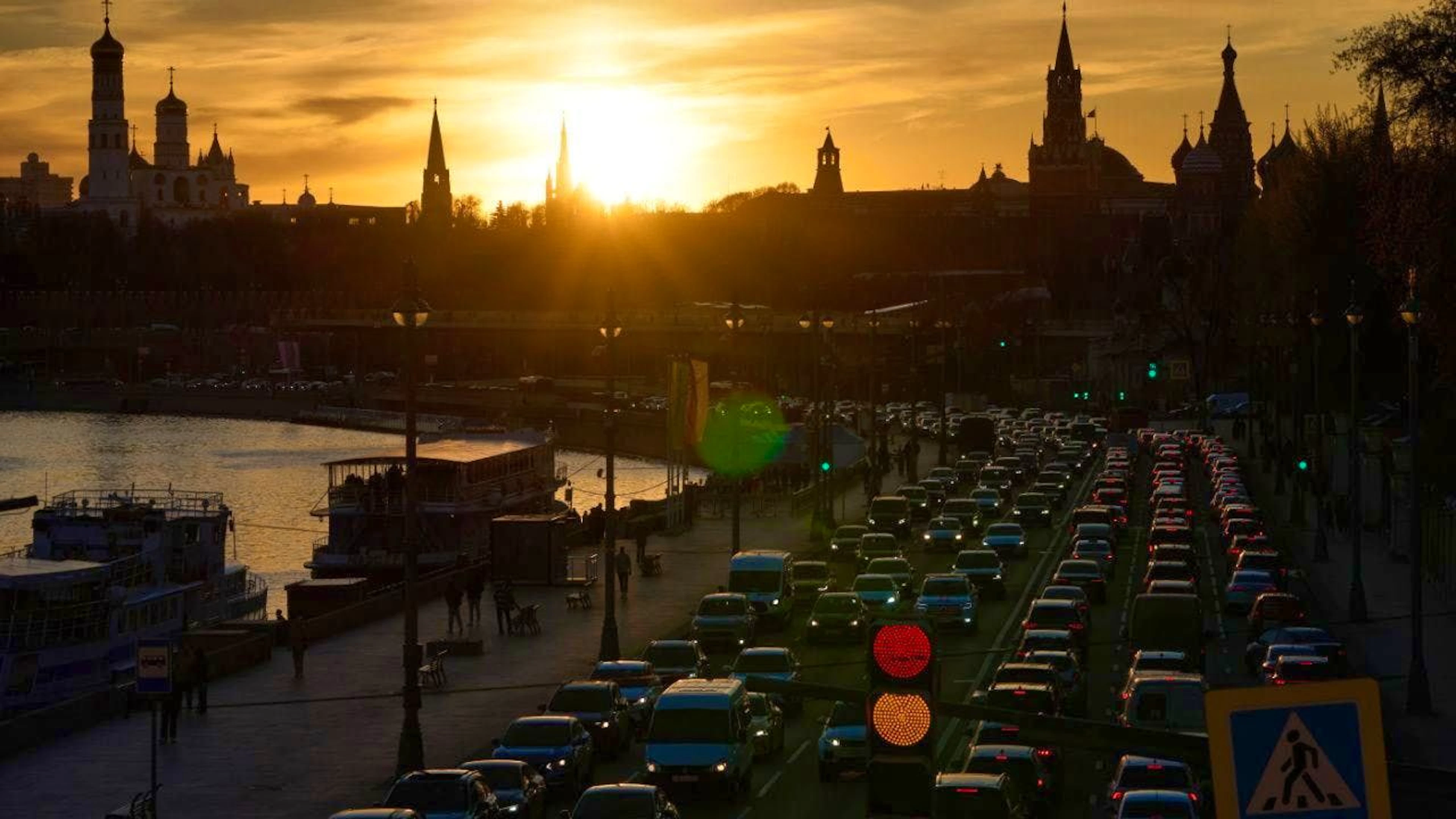 Cars drive along the Moskvoretskaya bank of the Moskva River at sunset, with the Kremlin in the background. Photo: Alexander Zemlianichenko/AP/dpa
