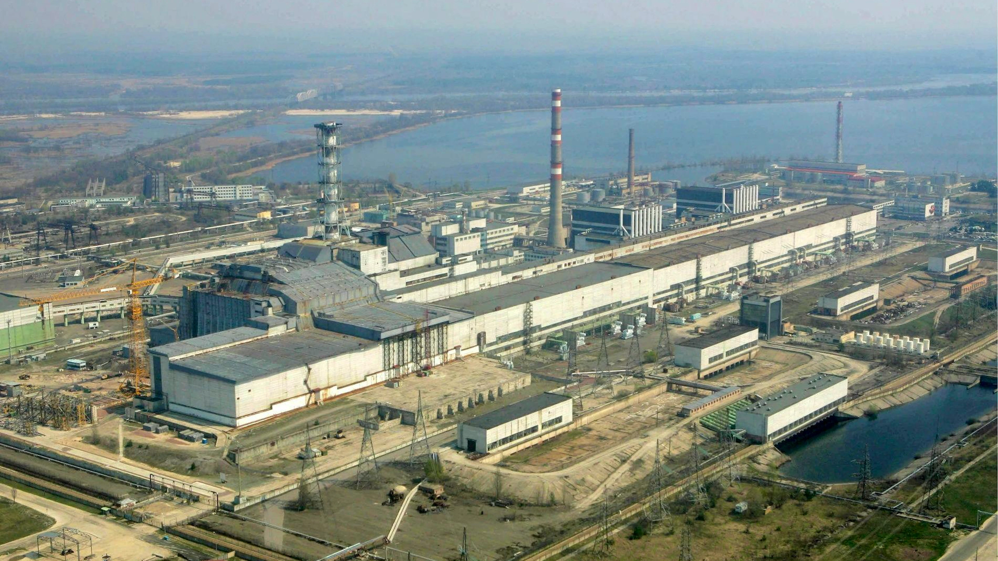 epa03581809 (ARCHIVES) Photo d'archive datée du 26 avril 2006 montrant une vue aérienne de la centrale nucléaire de Tchernobyl. Le toit de la salle des machines de la centrale nucléaire désaffectée de Tchernobyl s'est effondré sous le poids de la neige, a déclaré le ministère ukrainien des Situations d'urgence le 13 février 2013. Le toit ne faisait pas partie du sarcophage en béton recouvrant le réacteur qui a explosé en 1986, mais le bâtiment ne se trouvait qu'à environ 70 mètres de celui-ci. Il n'y a eu aucune fuite radioactive et personne n'a été blessé, a précisé le ministère. EPA/MYKOLA LAZARENKO / POOL