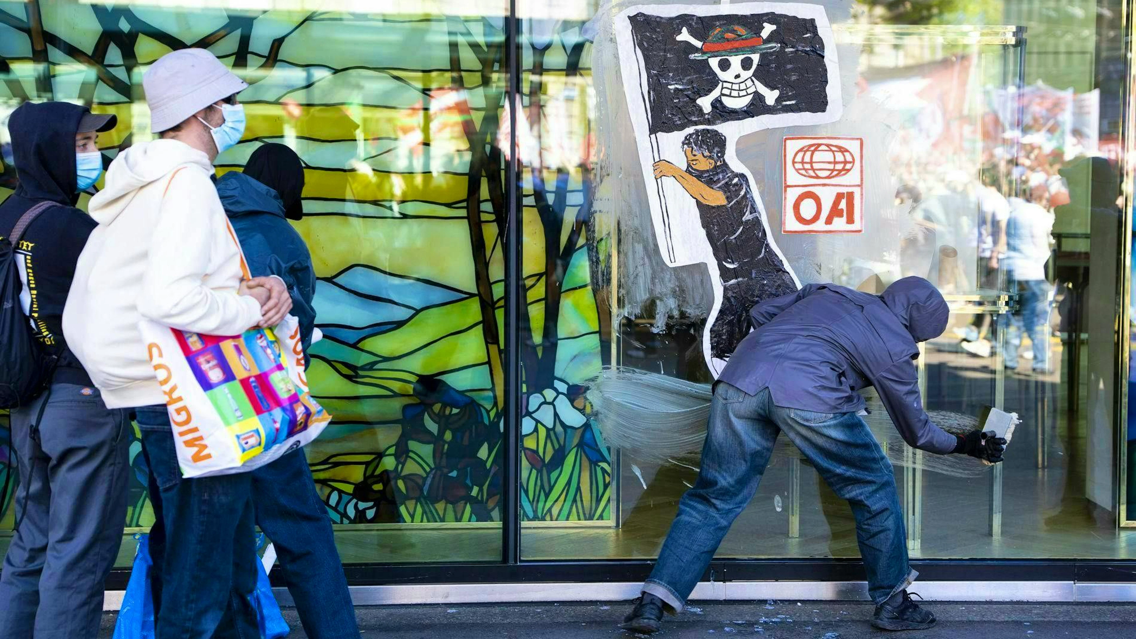 Demonstrators spray-painting a façade during the May Day demonstration.