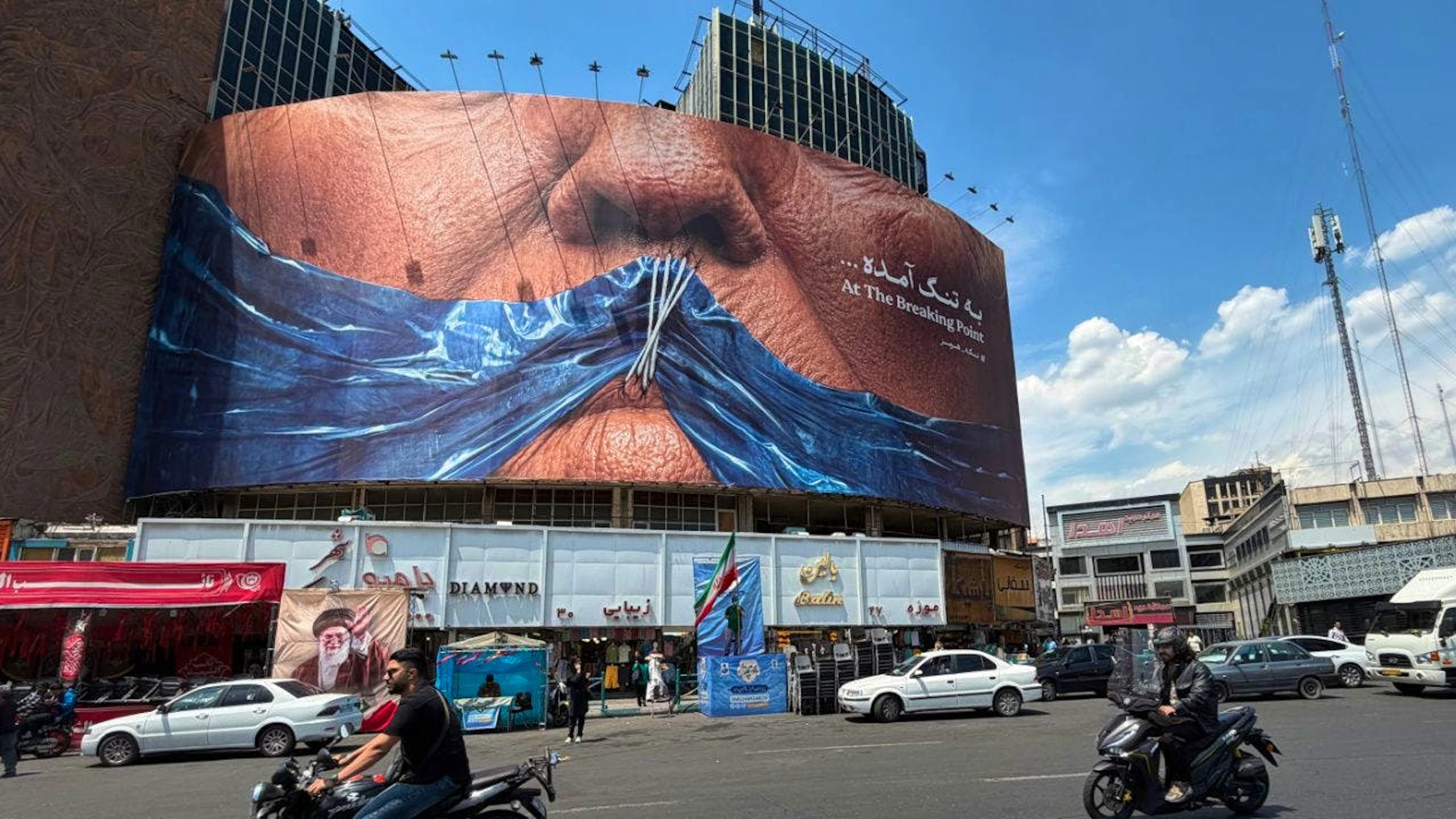 Des véhicules passent devant un panneau publicitaire montrant le détroit d’Ormuz et les lèvres cousues du président américain Donald Trump, sur une place du centre de Téhéran, en Iran, samedi.