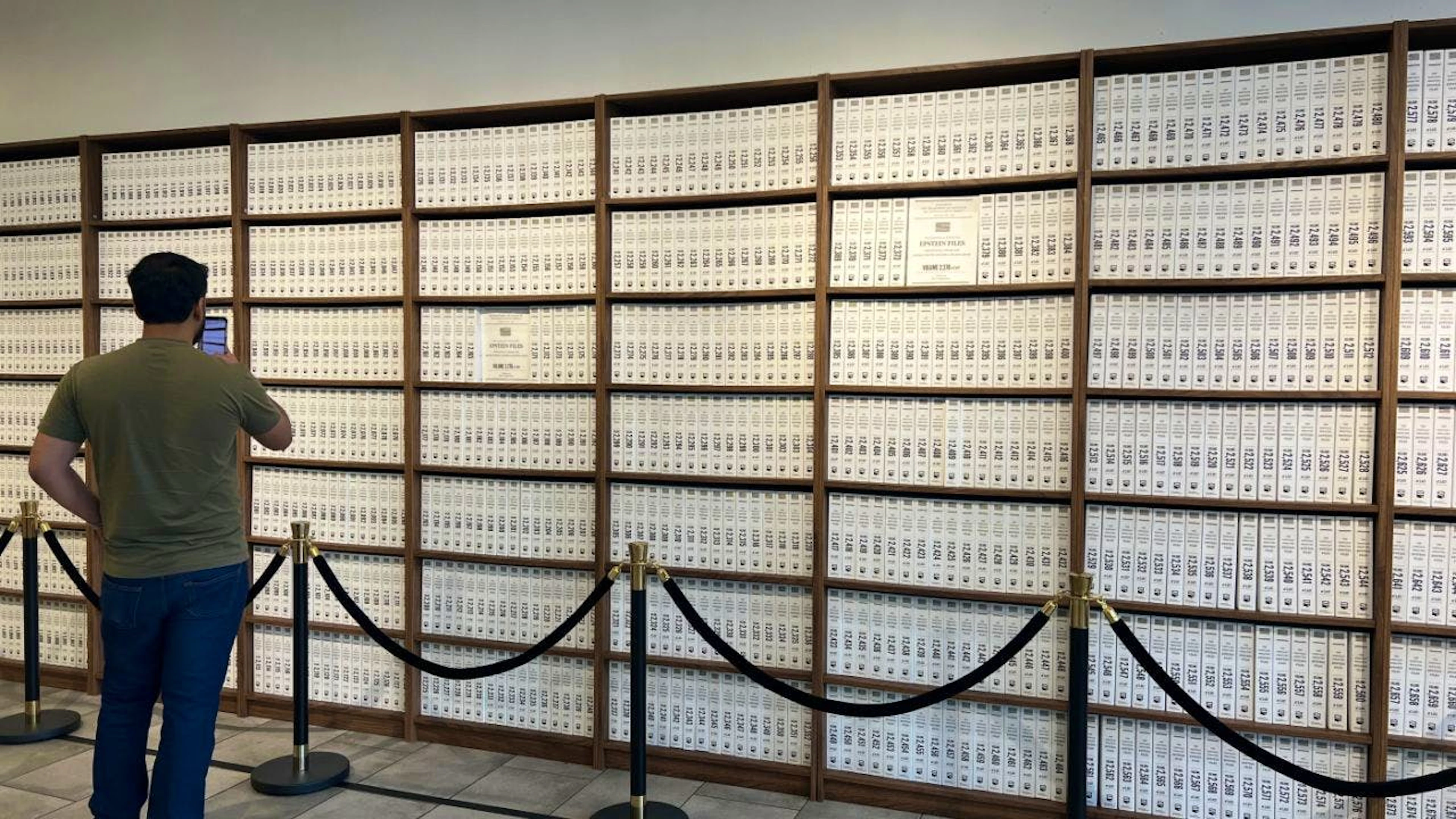 PRODUKTION – Ein Besucher steht im «Donald J. Trump and Jeffrey Epstein Memorial Reading Room» in einer Ausstellung, die die Epstein-Dokumente in 3.437 Büchern zeigt. Rund 3,5 Millionen Dokumente hat das US-Justizministerium zum Fall Epstein veröffentlicht. Das Ausmass will die Ausstellung nun greifbar machen. Foto: Christina Horsten/dpa