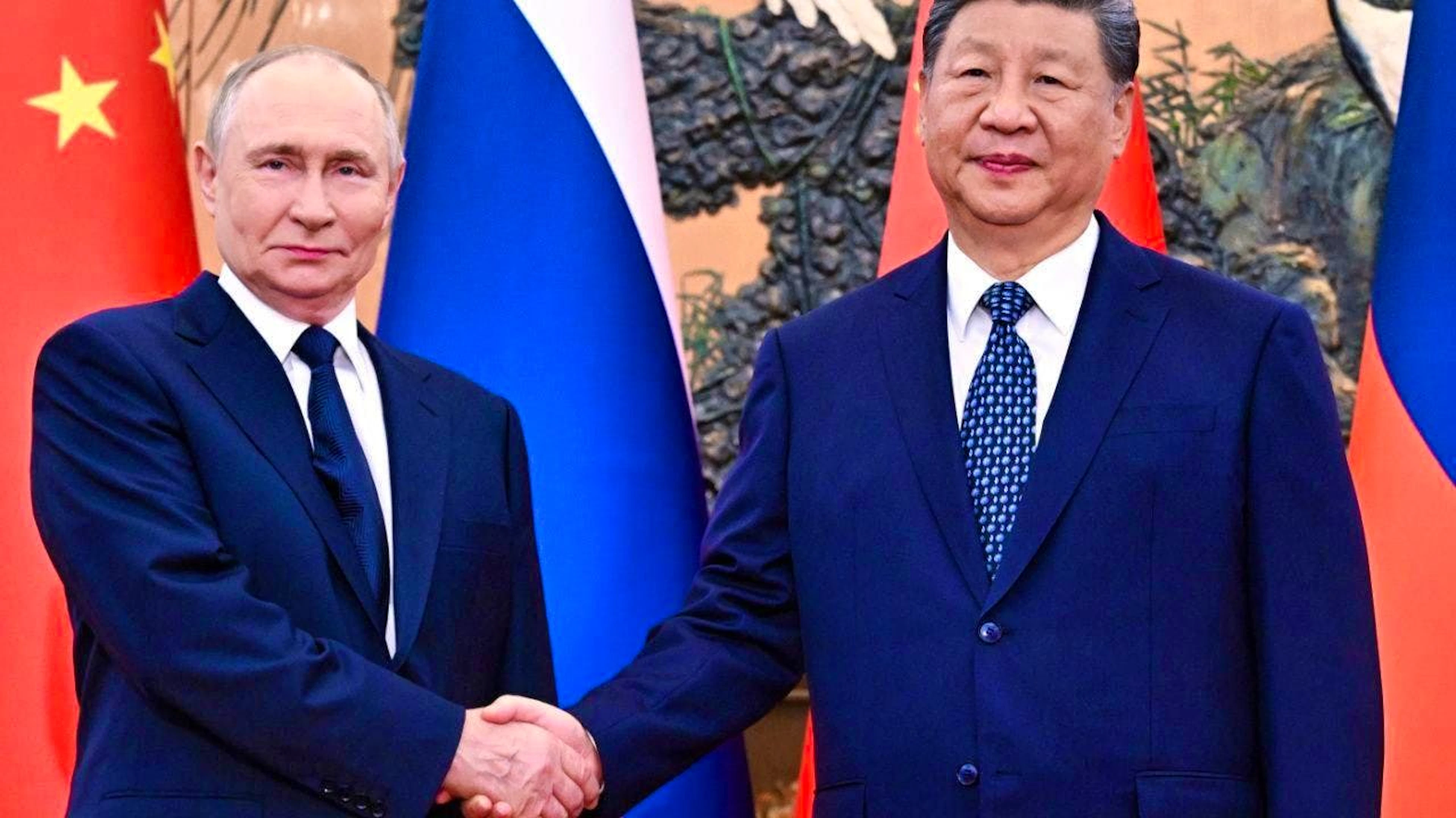 ARCHIVE - Russian President Vladimir Putin (l) and Chinese President Xi Jinping shake hands before their meeting in the Great Hall of the People. Photo: Sergei Bobylev/Pool Sputnik Kremlin/dpa - ATTENTION: For editorial use only and only with full attribution of the above credit