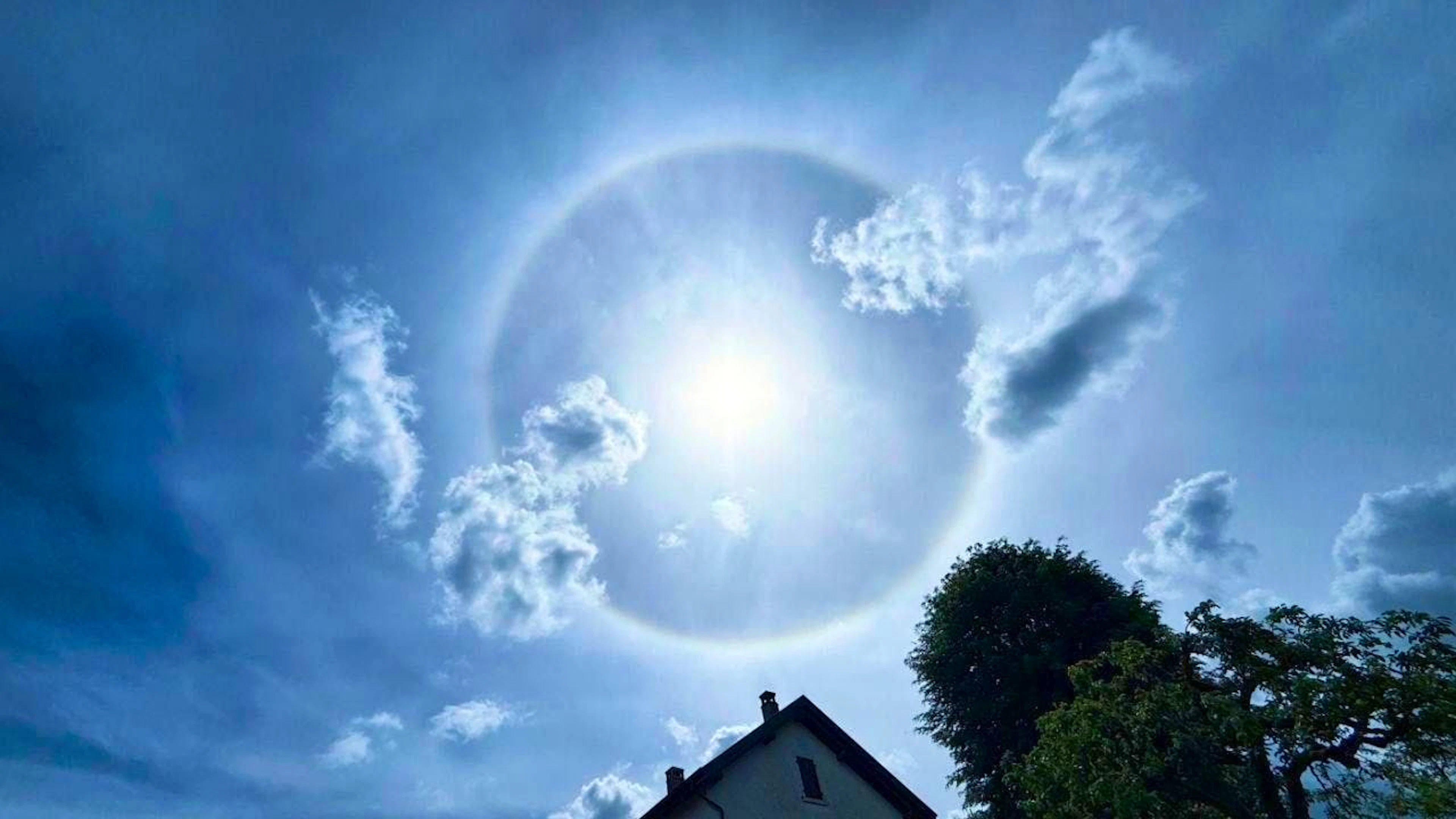 Il fenomeno dell'alone di 22 intorno al Sole è fotografato nel cielo blu di Porrentruy domenica.
