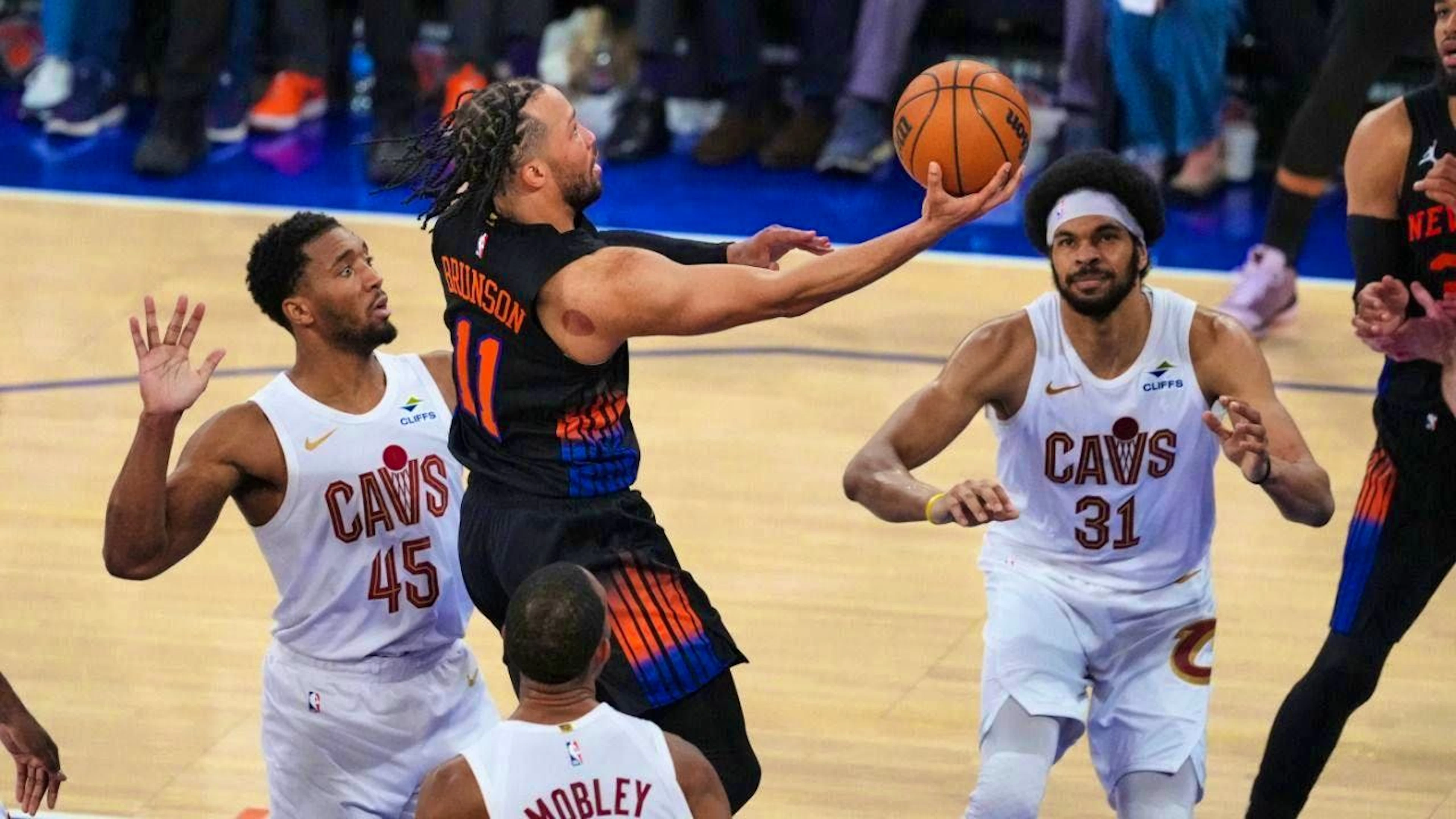 Knicks star Jalen Brunson (center) wins against three Cleveland players