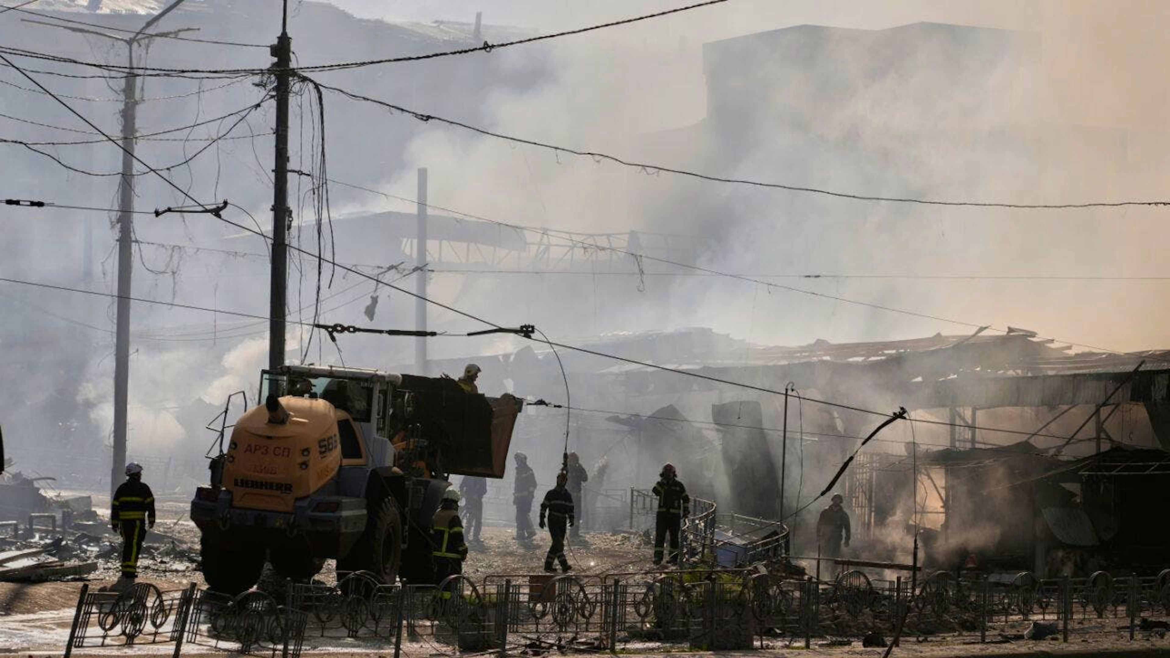 Feuerwehrleute löschen das Feuer auf einem Marktplatz in Kiew. Foto: Efrem Lukatsky/AP/dpa
