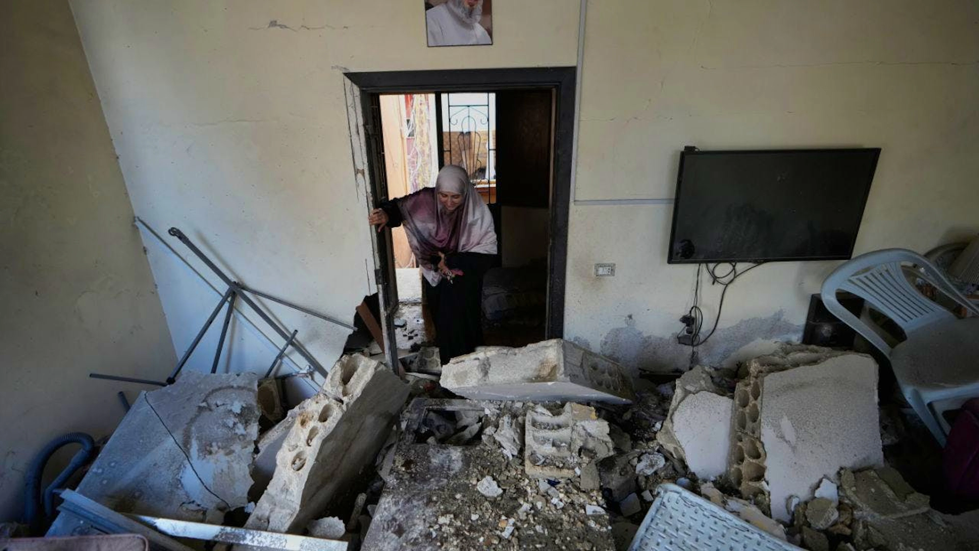dpatopbilder – Eine Frau betritt ihr Haus, das bei einem israelischen Luftangriff im Dorf Burj al-Shemali in der Nähe der südlichen Hafenstadt Tyrus zerstört wurde. Foto: Mohammed Zaatari/AP/dpa