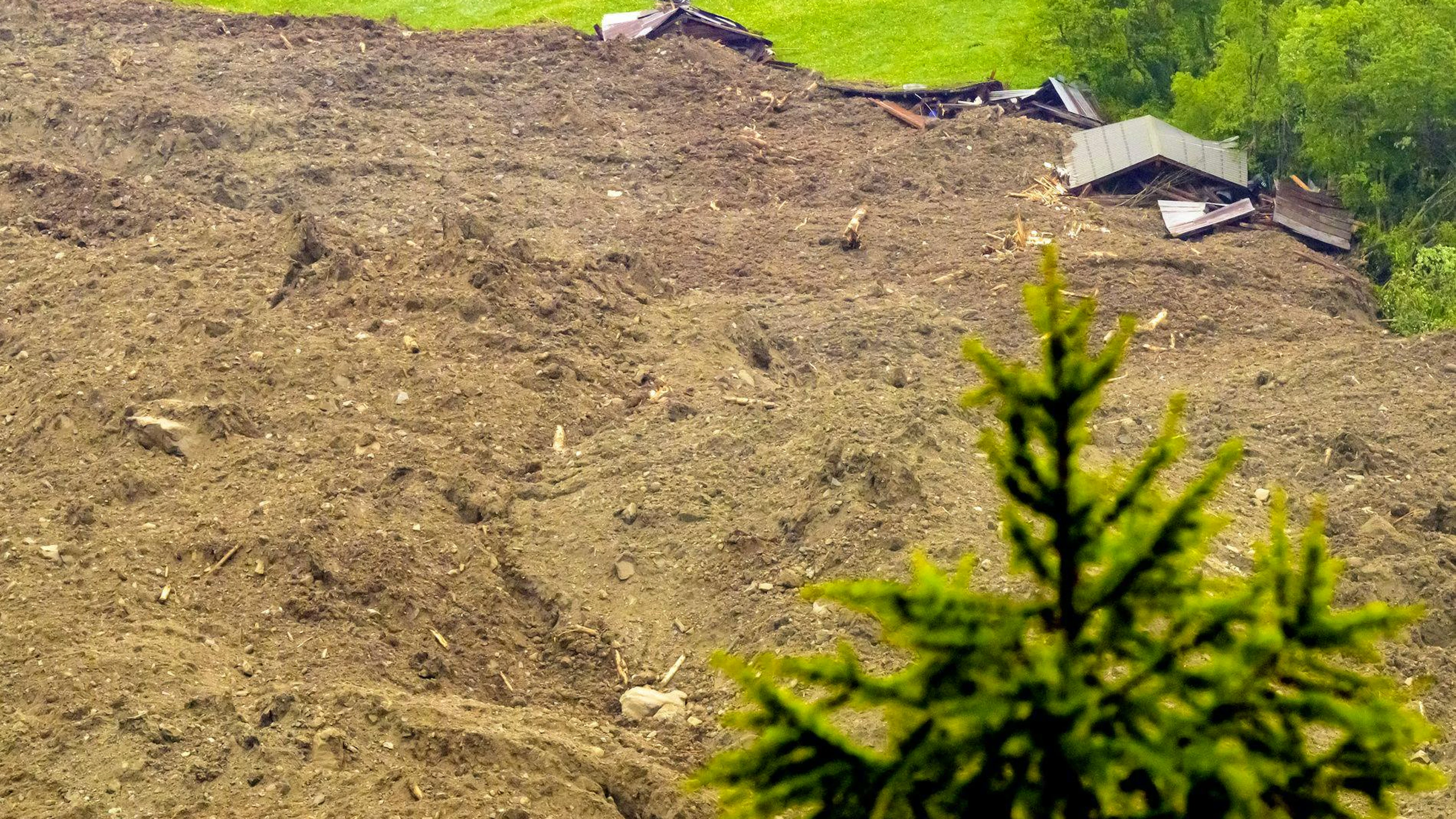 Une immense avalanche composée d'un mélange de glace, de roches, de neige et d'eau a atteint le fond de la vallée à Wiler, suite à l'effondrement du glacier de Birch au-dessus de Blatten, en Suisse, le mercredi 28 mai 2025. (KEYSTONE/Jean-Christophe Bott)