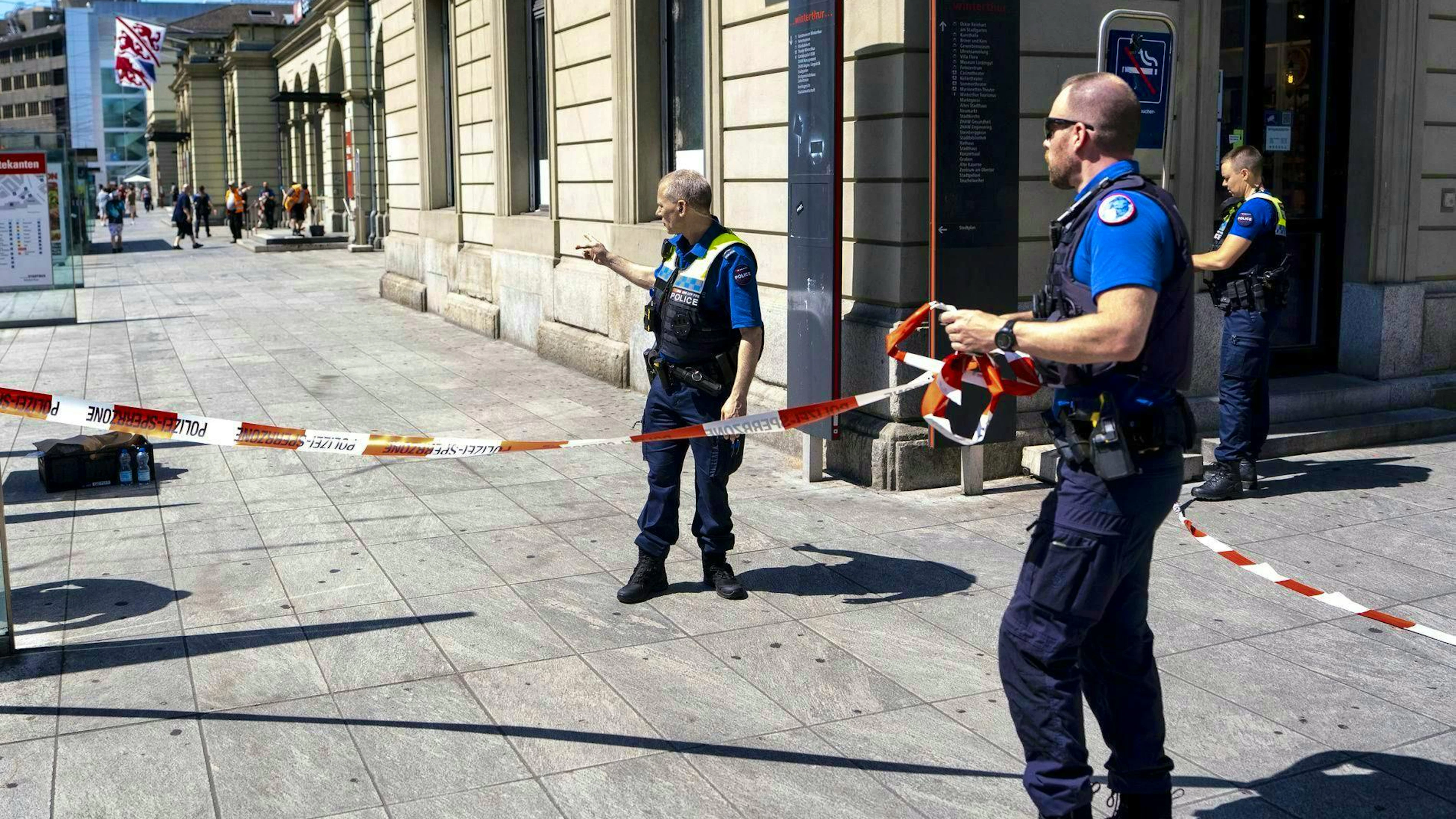 Police officers remove a barrier tape after a 31-year-old Swiss man attacked several people with a stabbing weapon at Winterthur railroad station.
