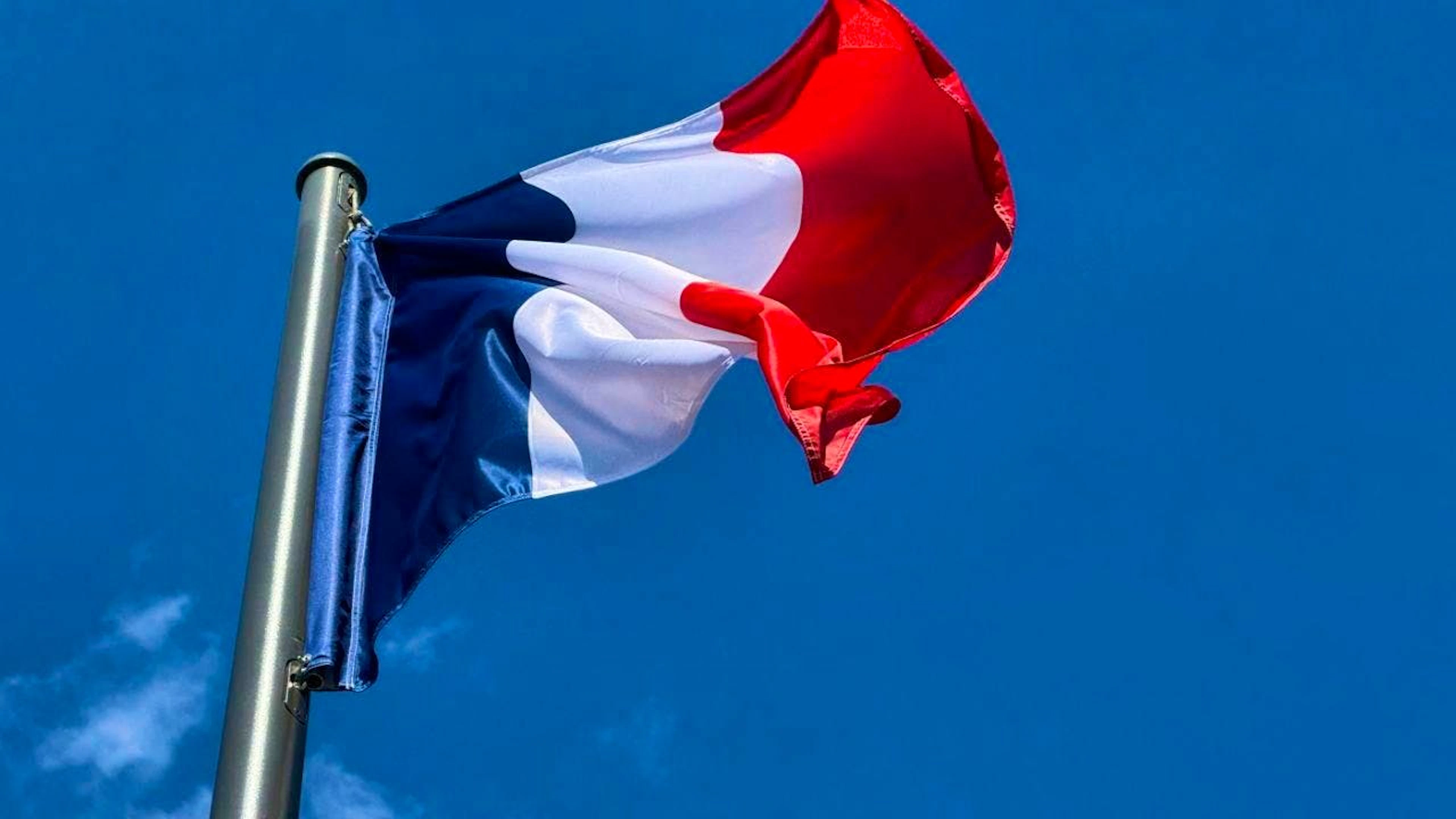 ARCHIVE - The French flag, also known as the tricolor, flies against a blue sky in central Paris. Photo: Rachel Sommer/dpa