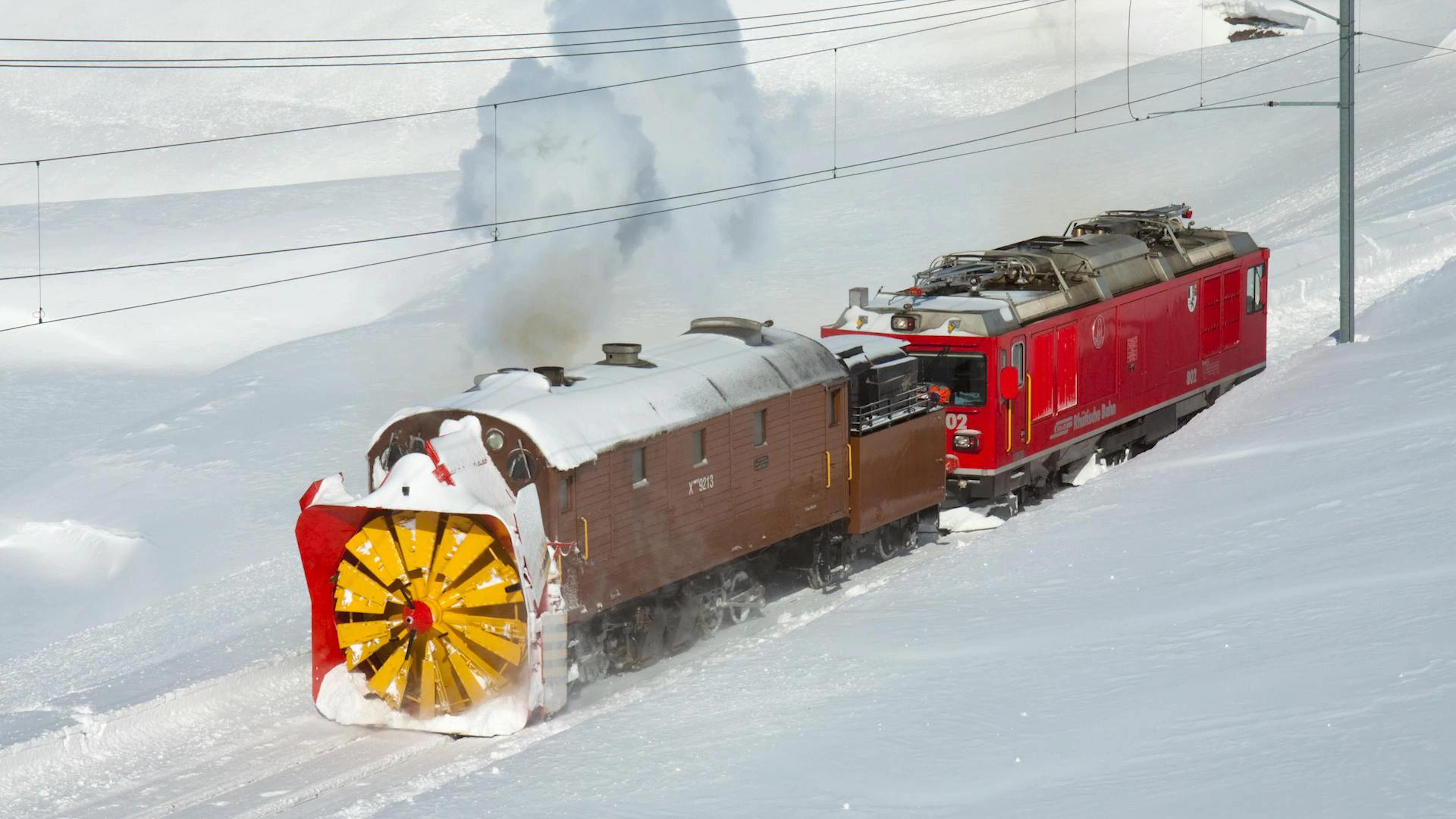 Selbst im Winter sind historische Fahrten möglich: Der legendäre RhB-Schneeschleuderzug Xrot räumt die Strecke durch die verschneite Bündner Bergwelt.