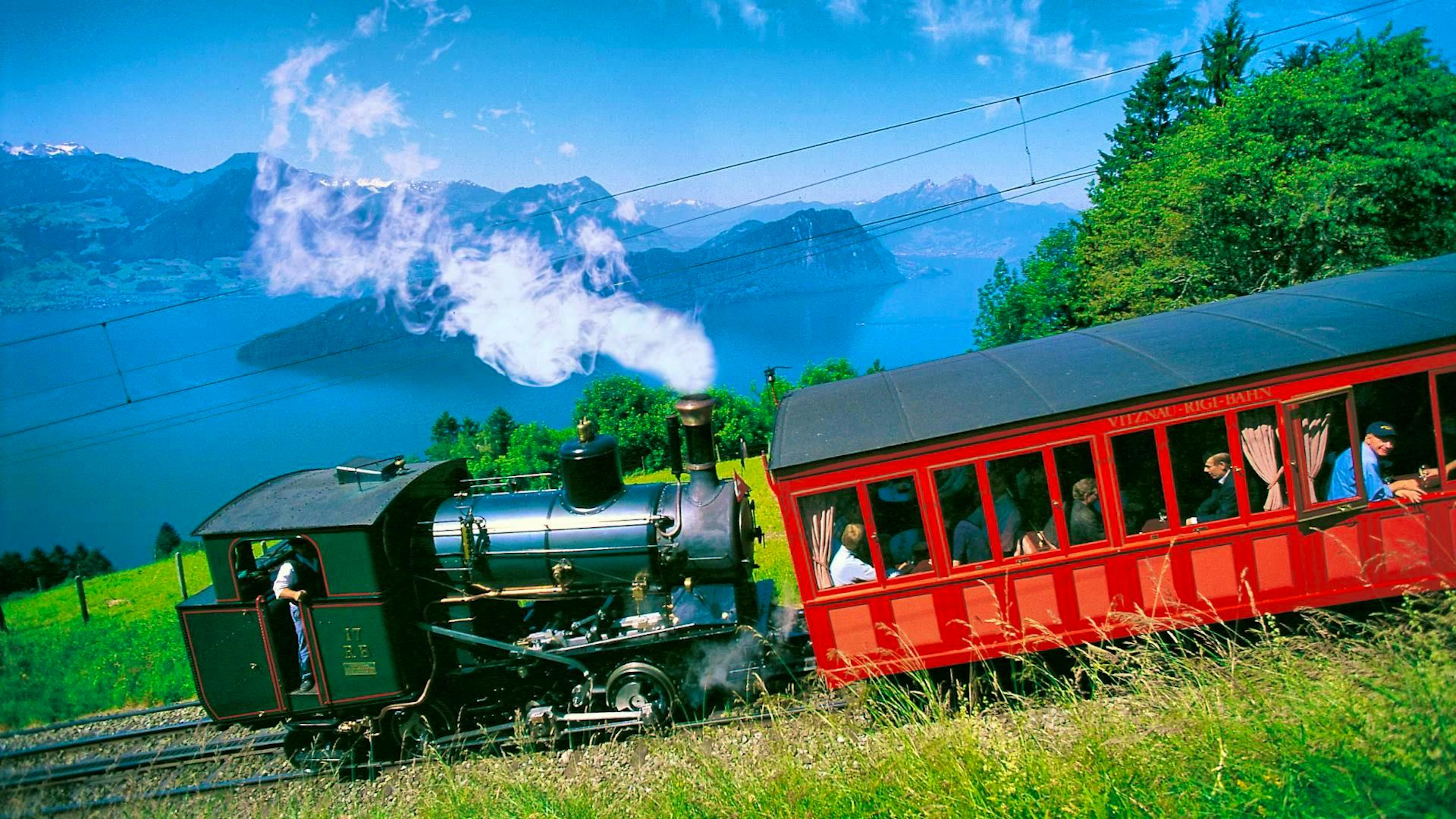 The historic Rigi Railway, Europe's first mountain railroad, travels with its steam locomotive high above Lake Lucerne towards the summit.